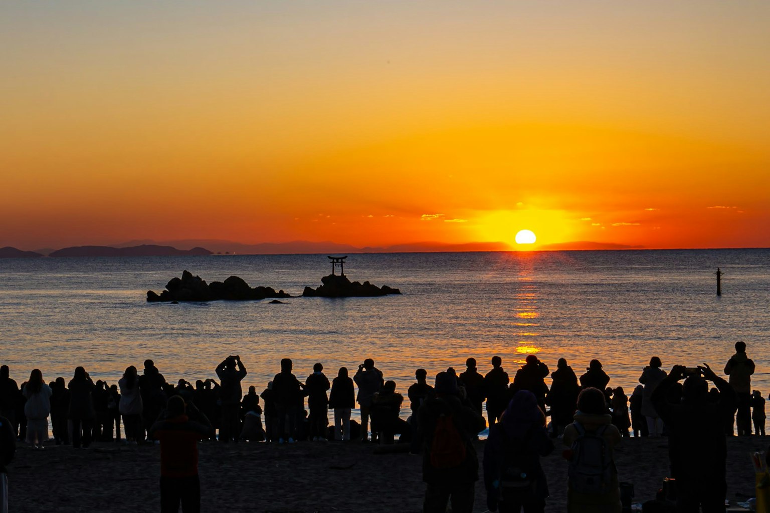 Silhouette di persone che osservano un bellissimo tramonto sulla spiaggia