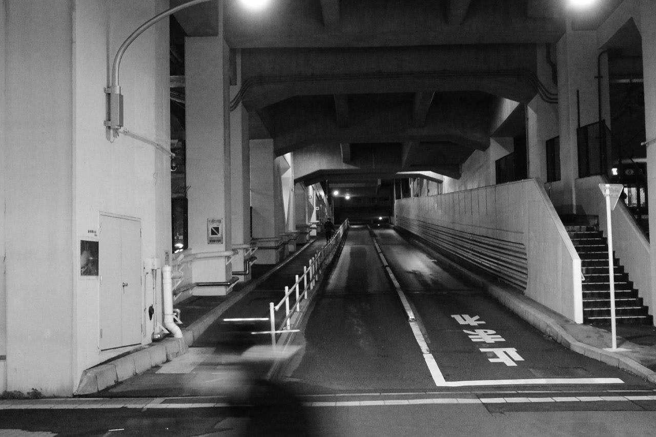 高架下の暗い通路と車線のある道路の夜景