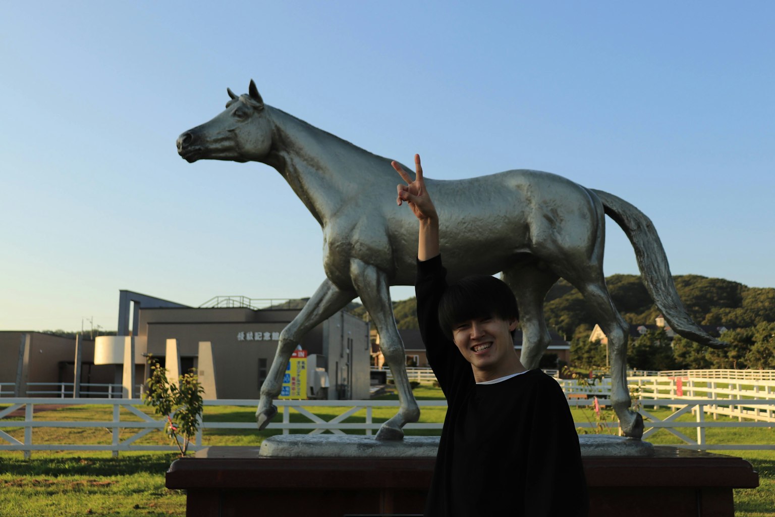 Personne posant devant une statue de cheval