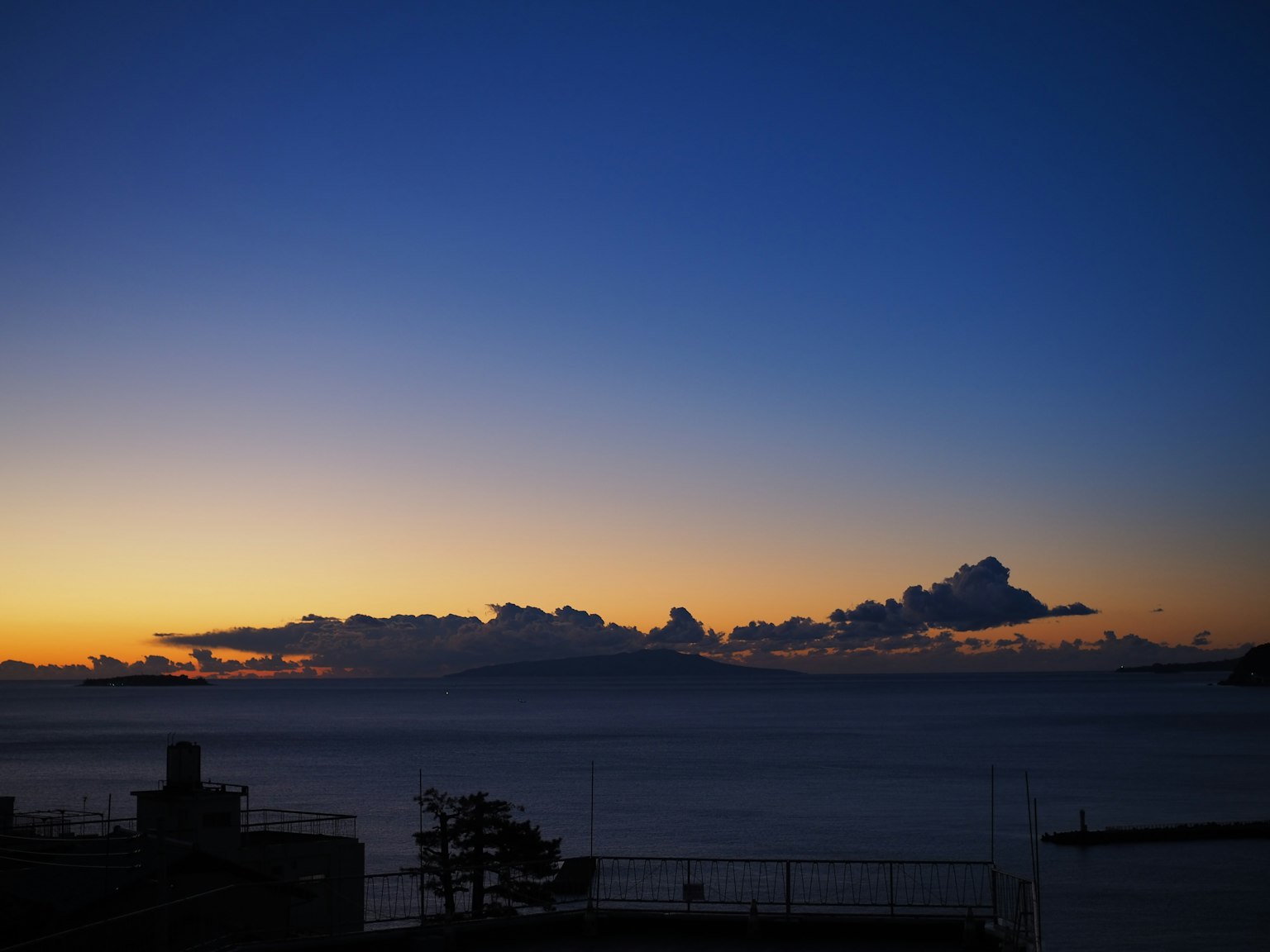 Senja di atas laut dengan awan di langit biru
