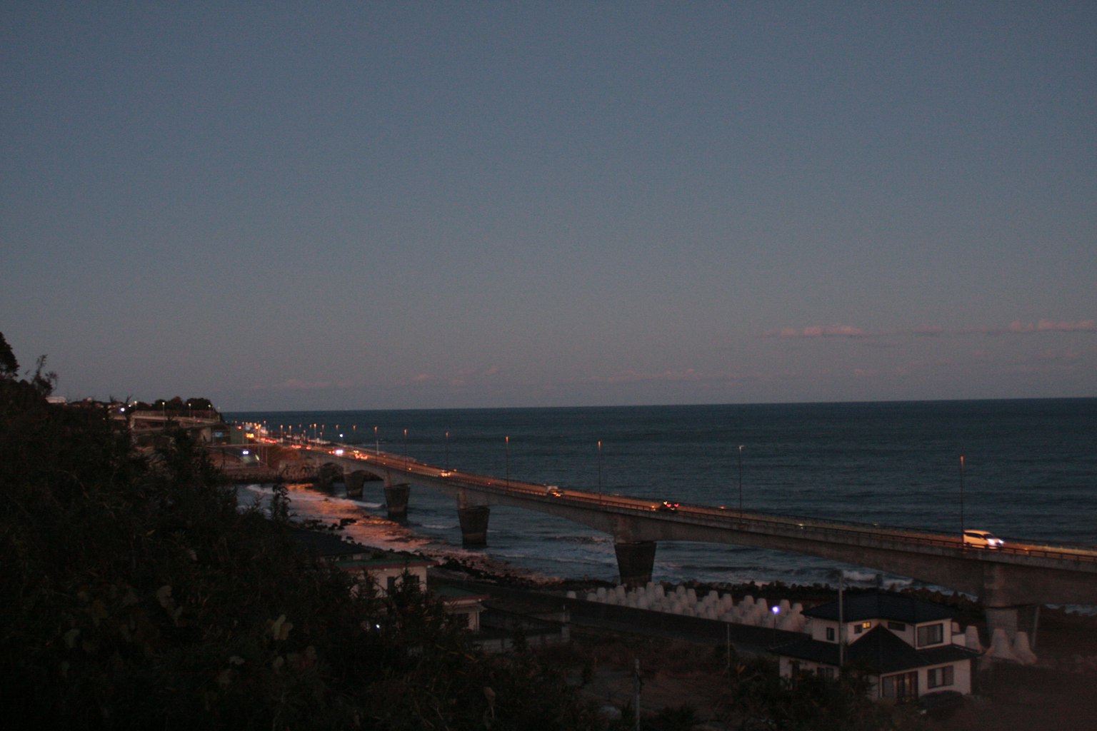 Coastal scene at night with illuminated road and ocean