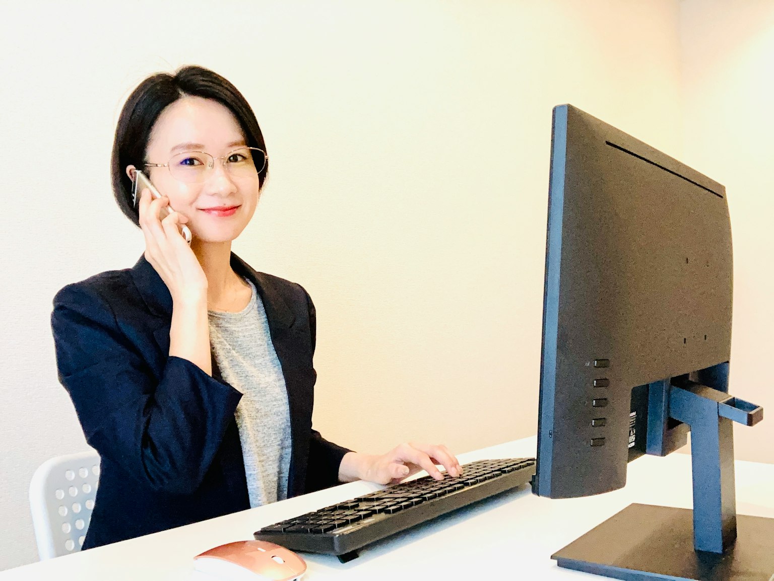 Donna che usa un computer mentre parla al telefono in un ufficio