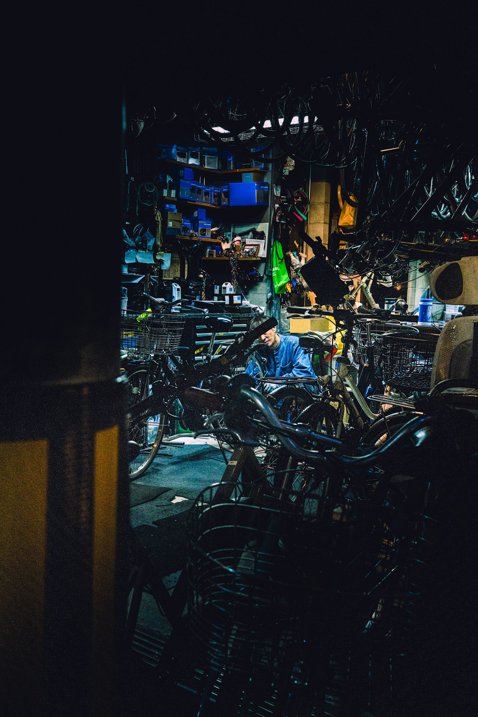 Un taller de reparación de bicicletas con una persona trabajando entre numerosas bicicletas
