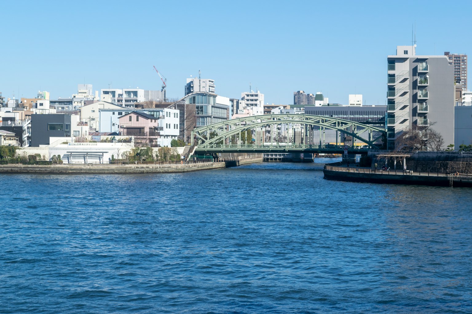 Brücke über einen blauen Fluss mit modernen Gebäuden im Hintergrund