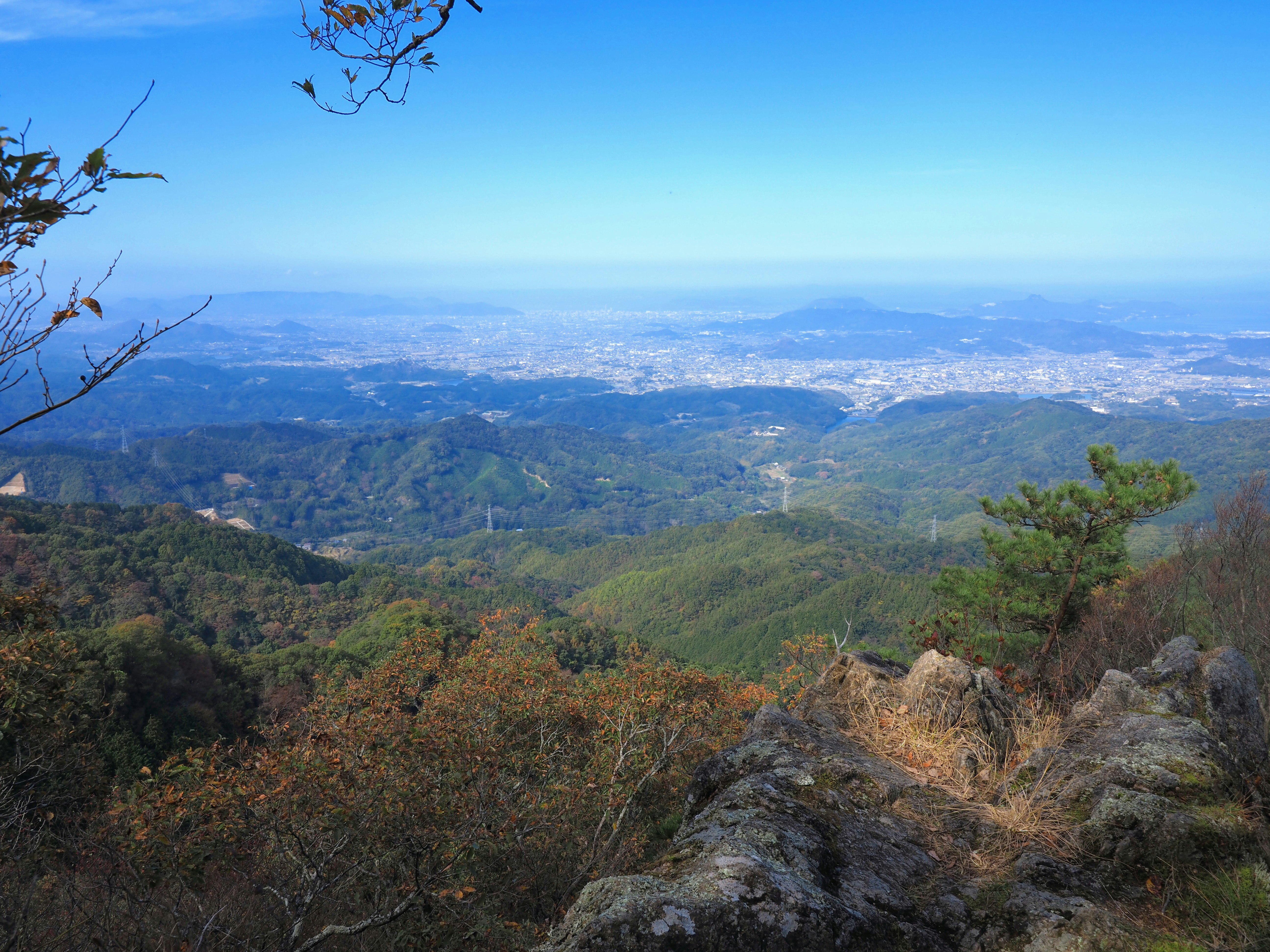 山の稜線から見渡す広大な渓谷と遠景の街並み