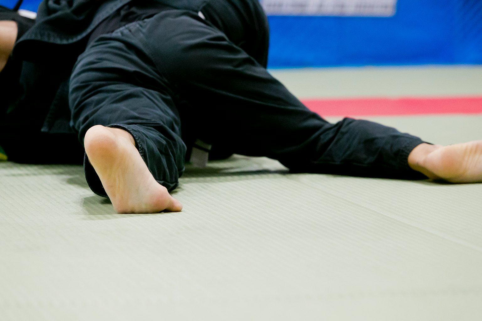 Primo piano dei piedi di due atleti durante un allenamento di judo in un dojo