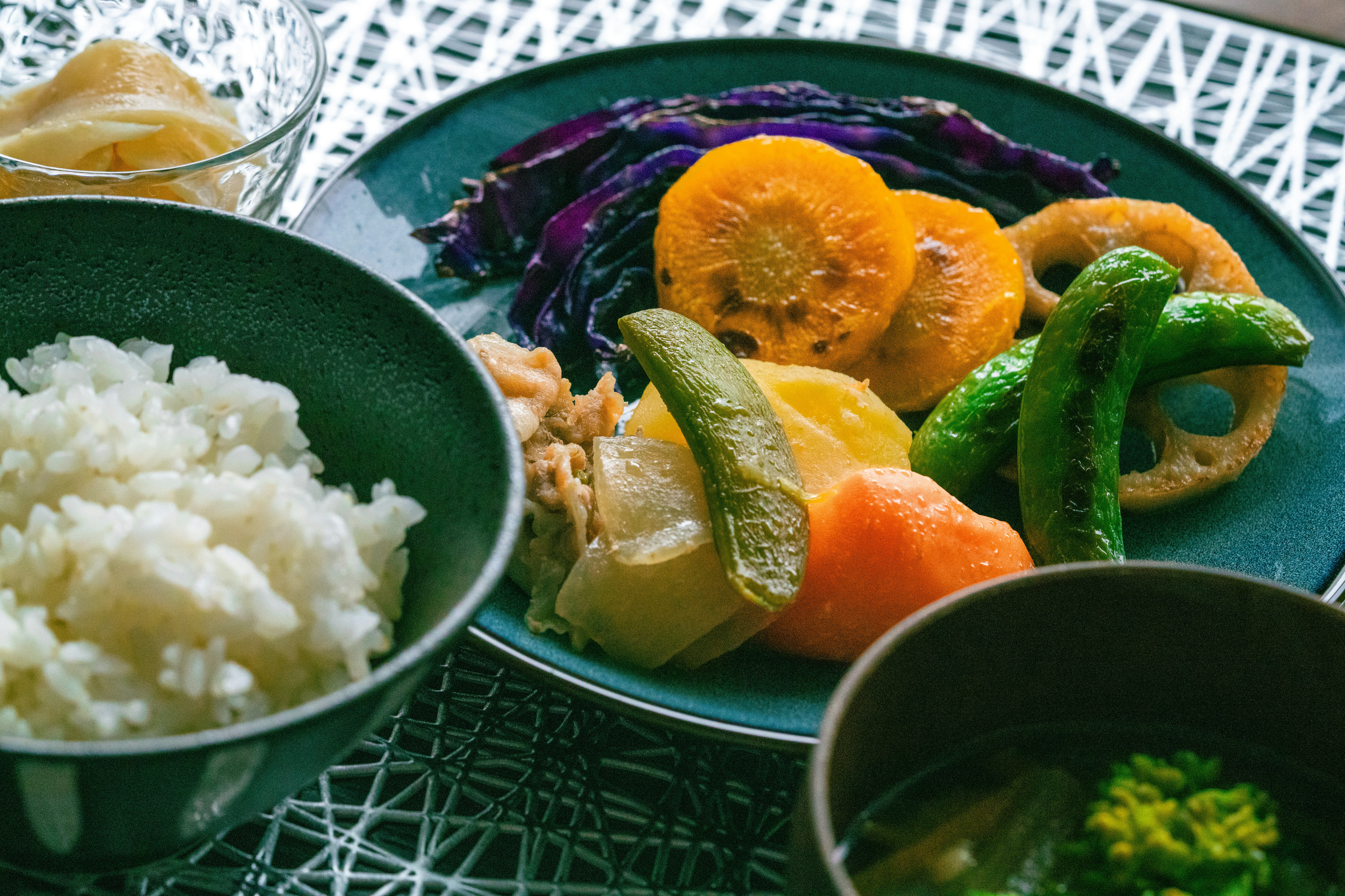 緑の皿に盛られた野菜とチキンのカレー風プレート