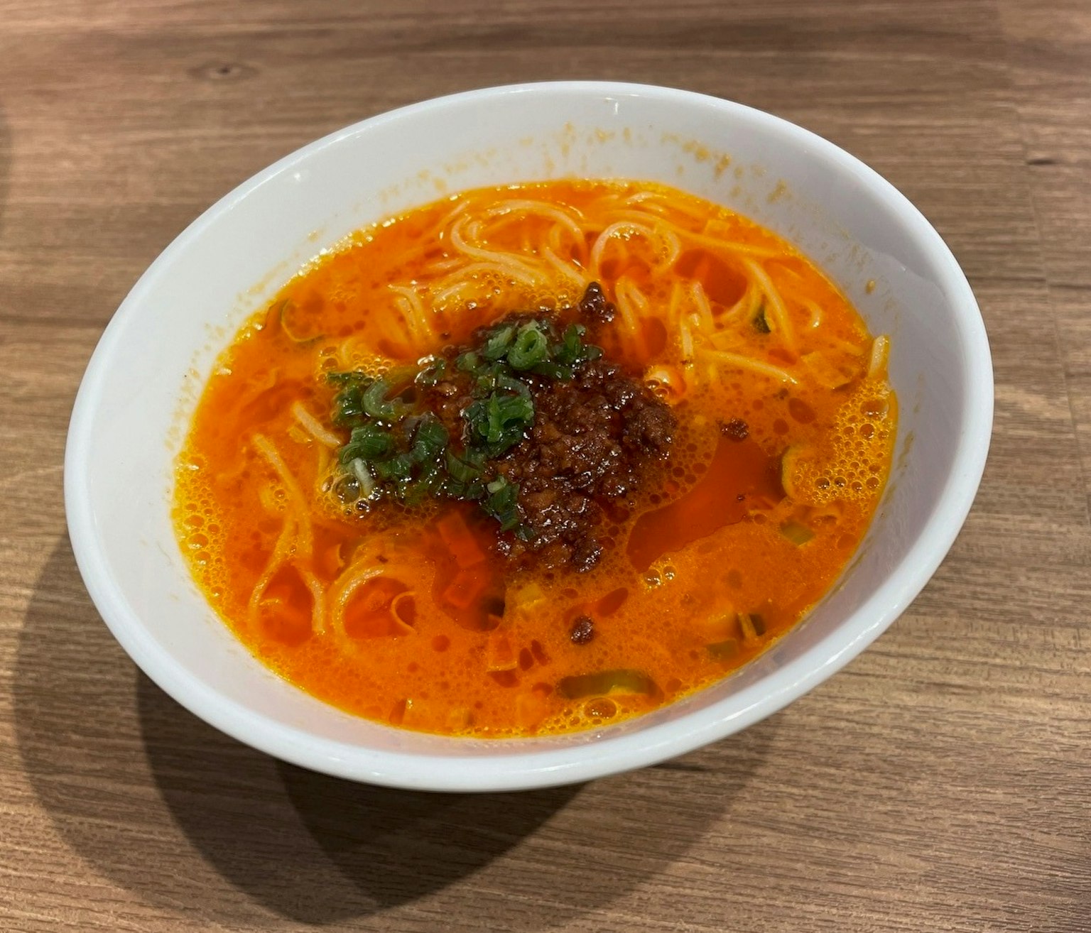 Eine Schüssel scharfe Nudelsuppe mit Kräutern und Chiliöl