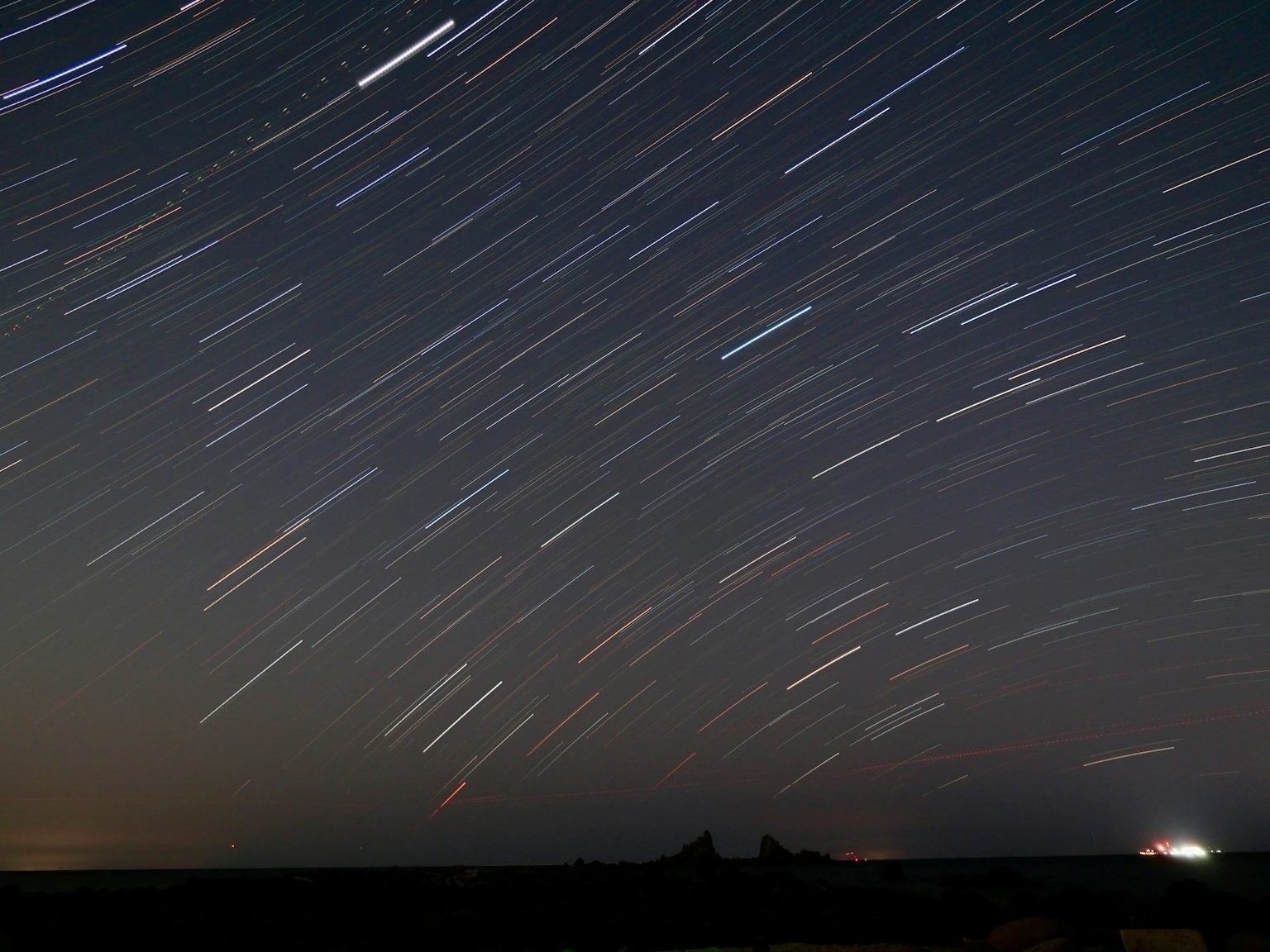 Ciel nocturne avec des traînées d'étoiles capturées en longue exposition
