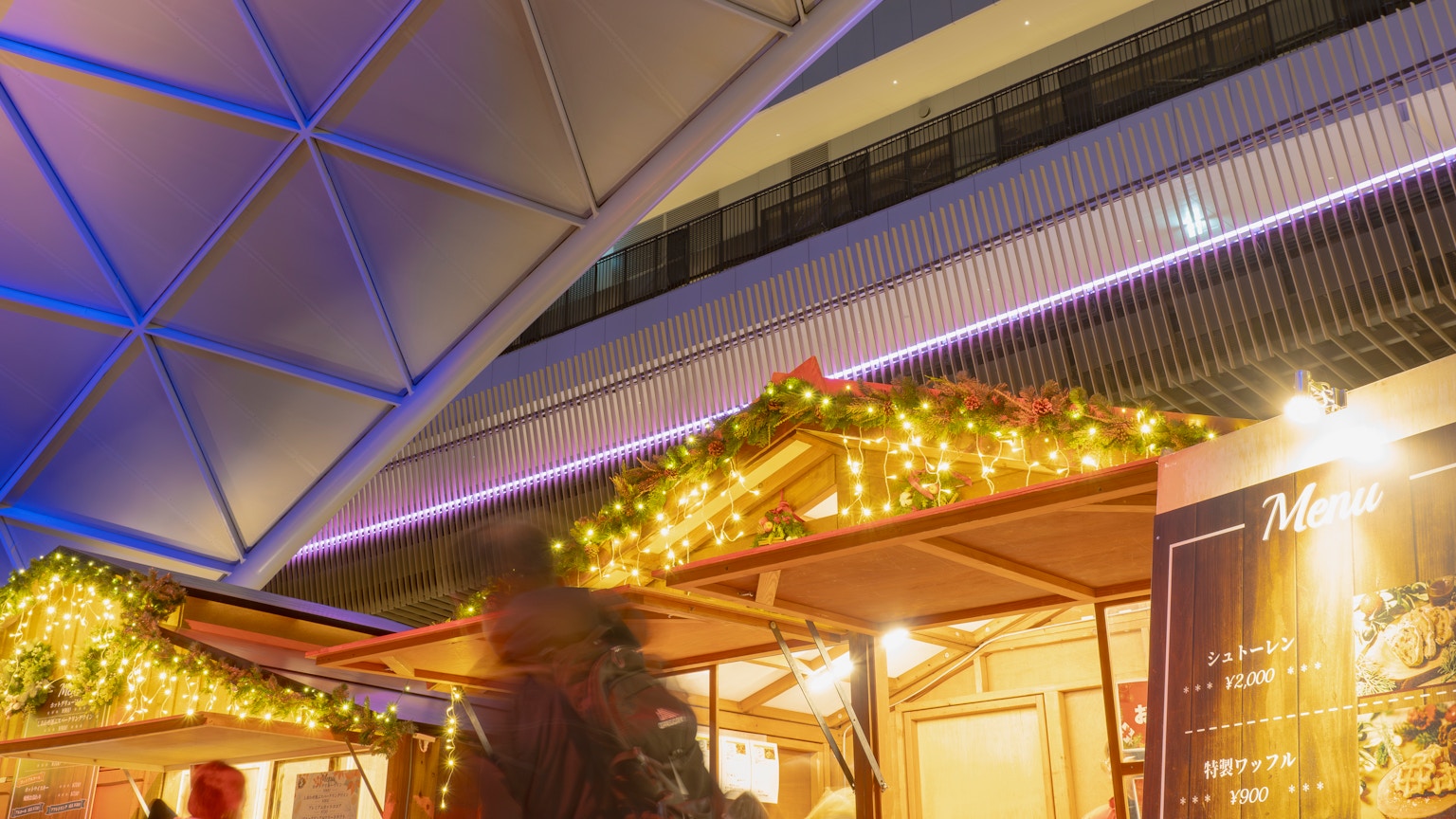 Puesto de mercado navideño con luces brillantes y techo decorado