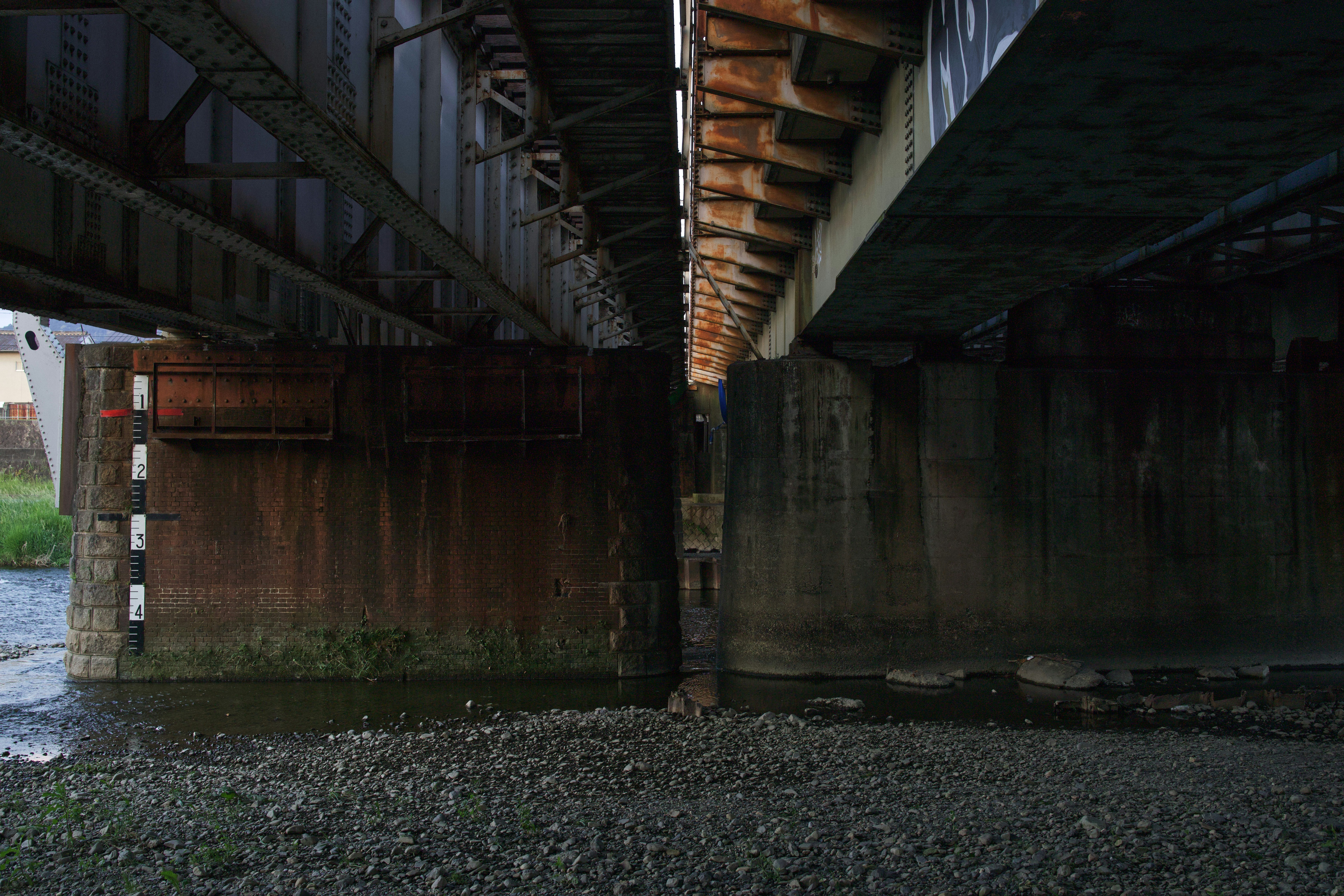 Underneath a railway bridge with exposed rocks and water