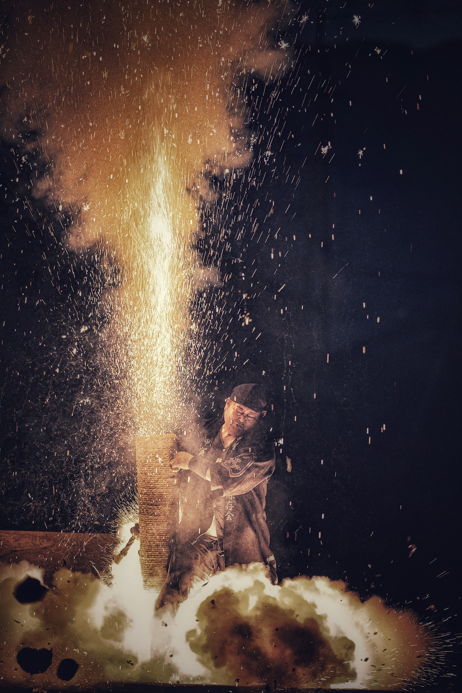 Pekerja dengan api eksplosif yang memancarkan percikan dan asap