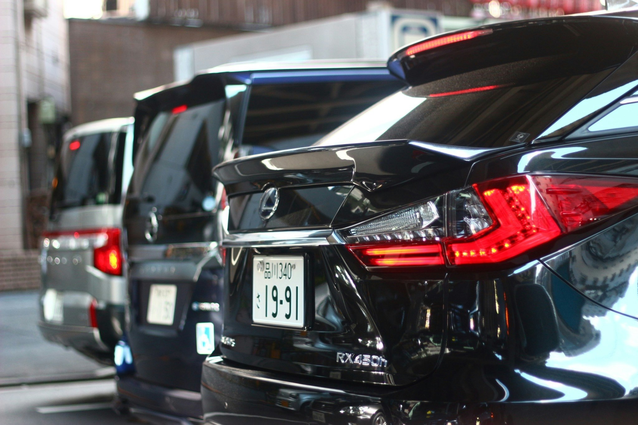 路地に並ぶ車のリアビューと輝くボディ