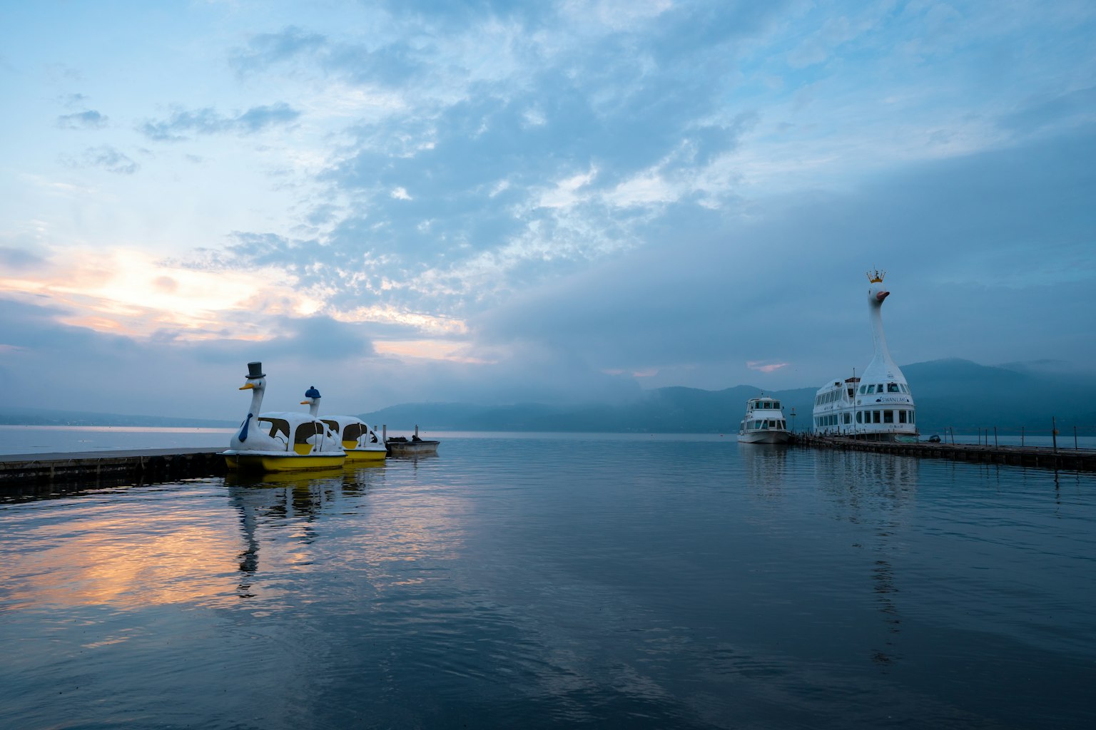 Malersicher Blick auf gelbe Boote und ein weißes Schiff auf ruhigem Wasser