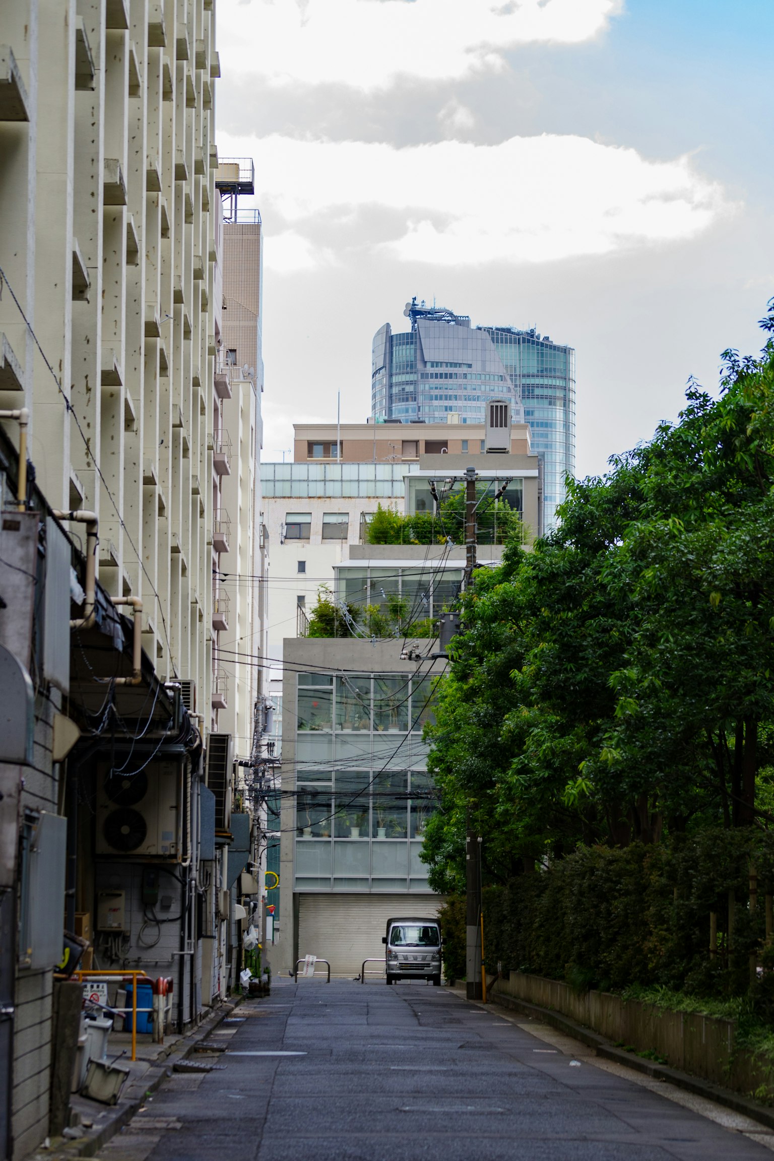 Strada stretta fiancheggiata da edifici moderni e alberi verdi