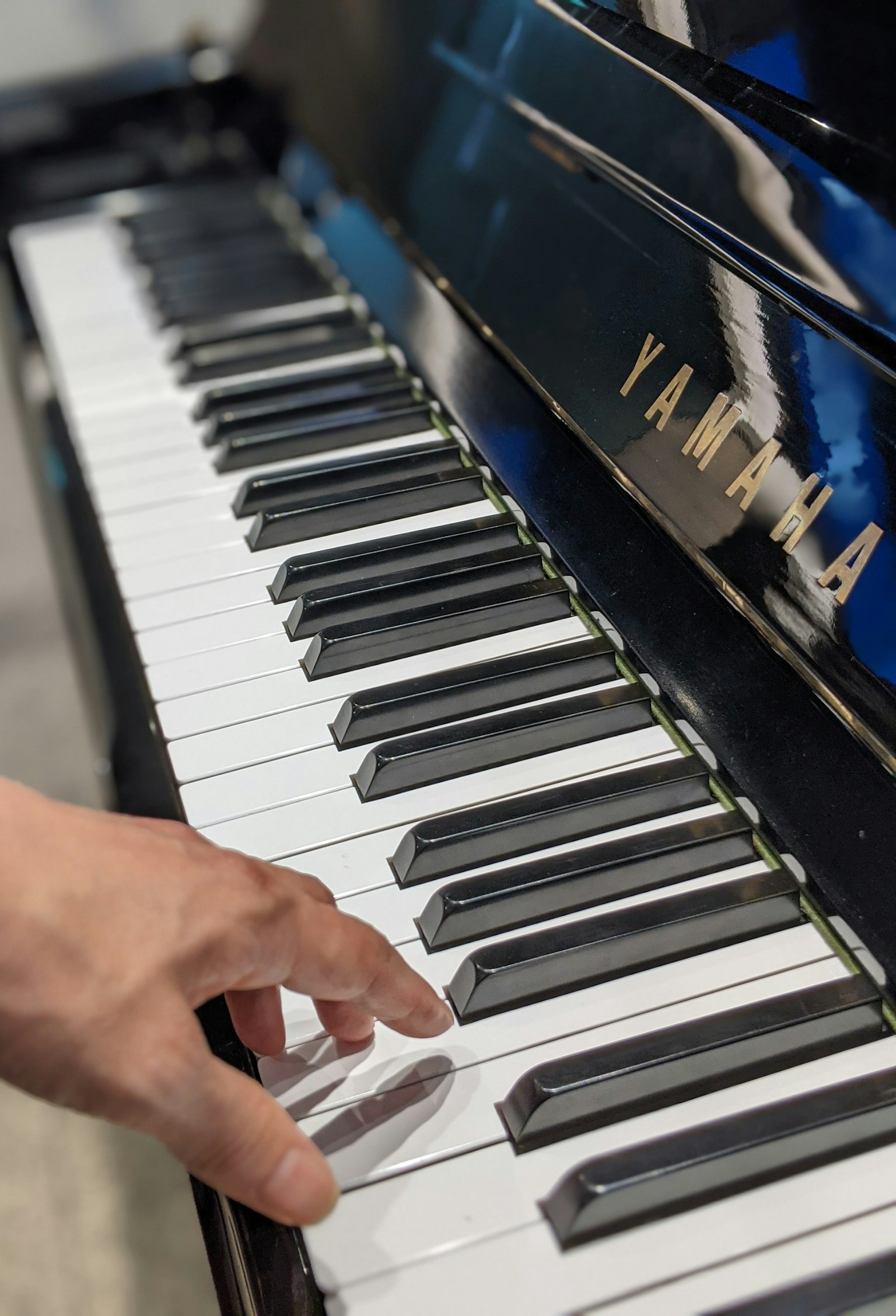 Mano che tocca i tasti di un pianoforte Yamaha
