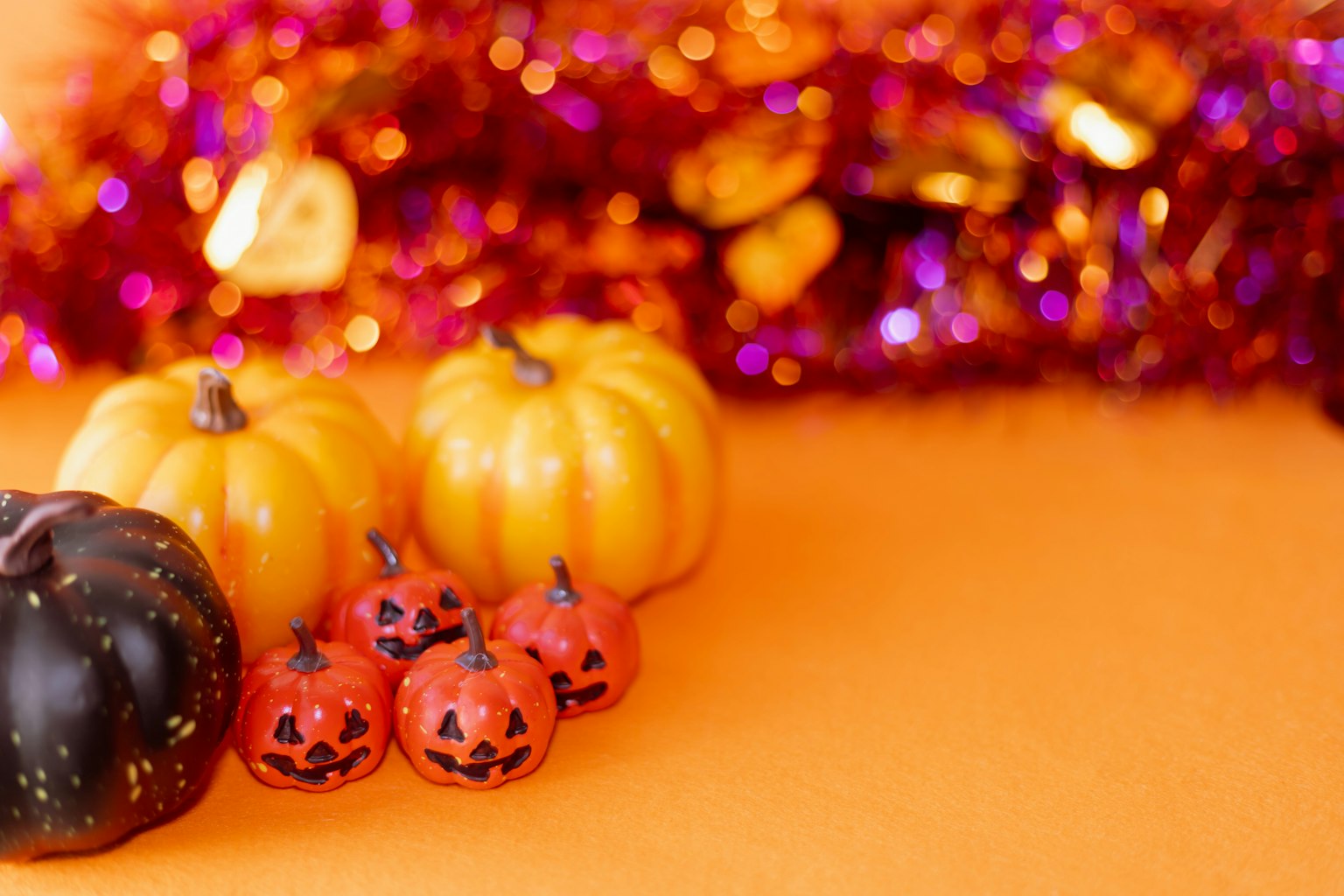 Zucche colorate e decorazioni di Halloween su uno sfondo arancione