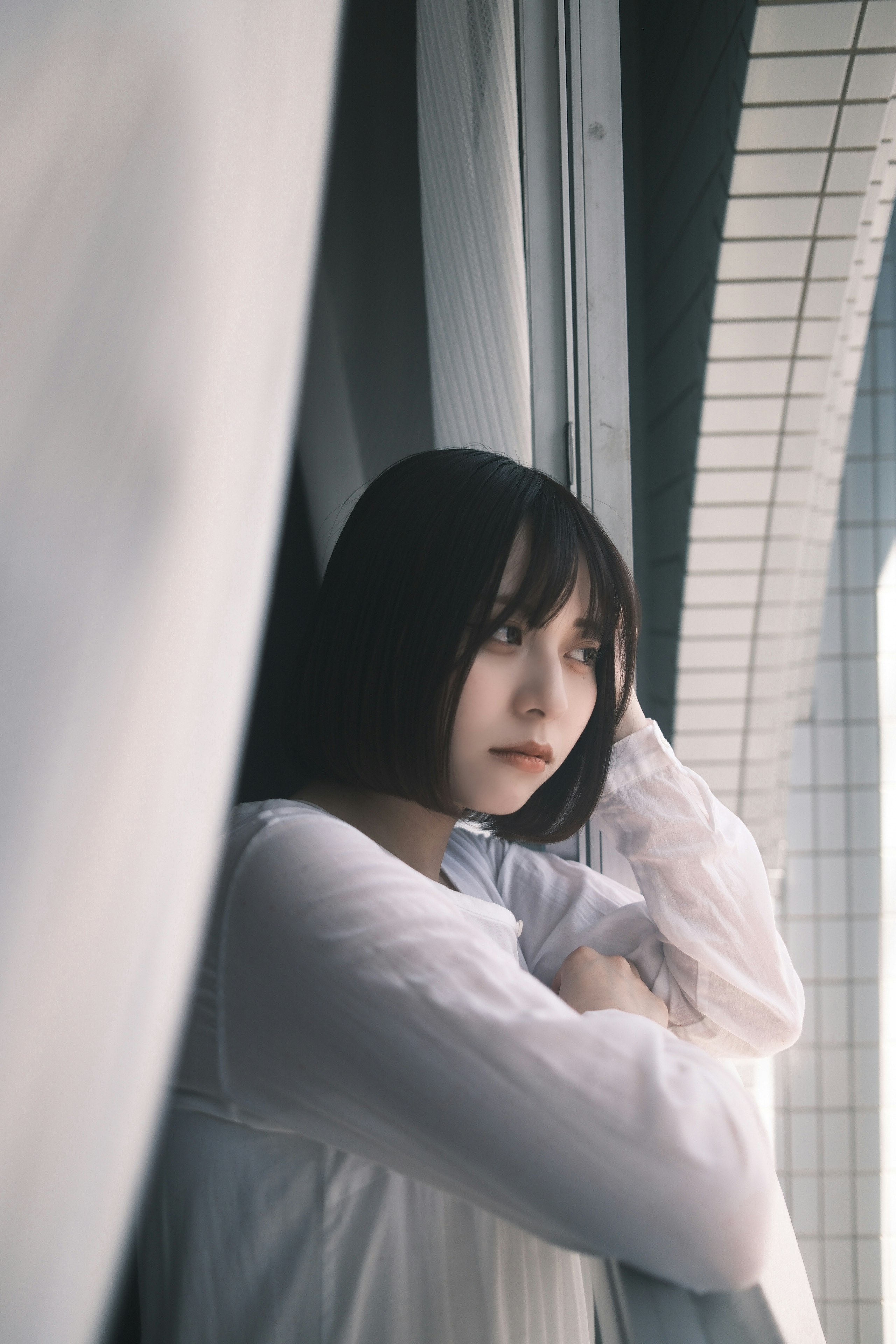 窗邊抱臂的女性肖像