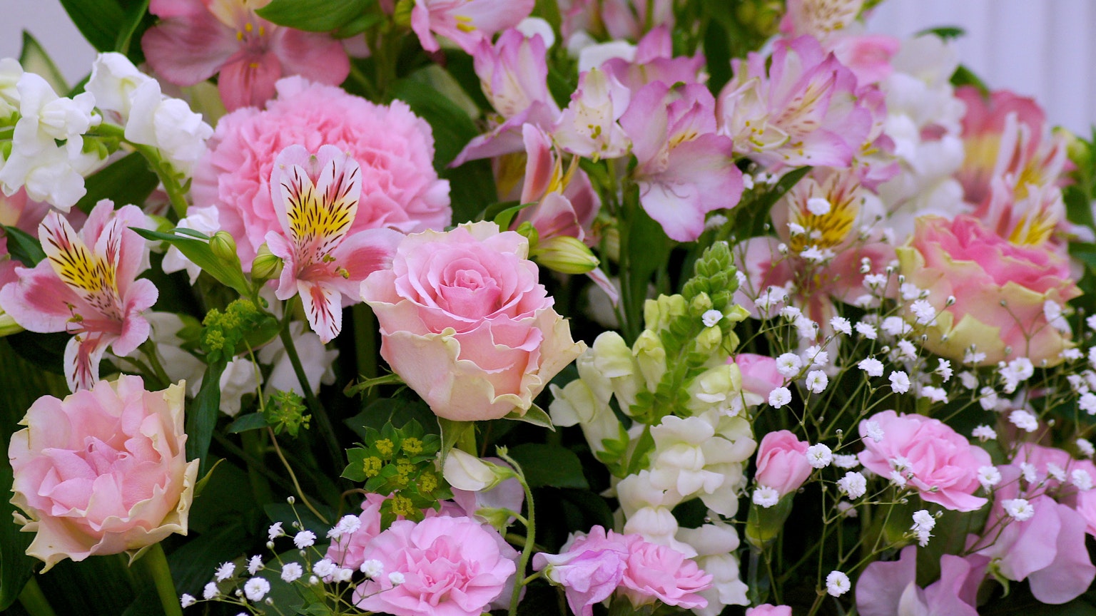 A beautiful arrangement of pink roses and white flowers