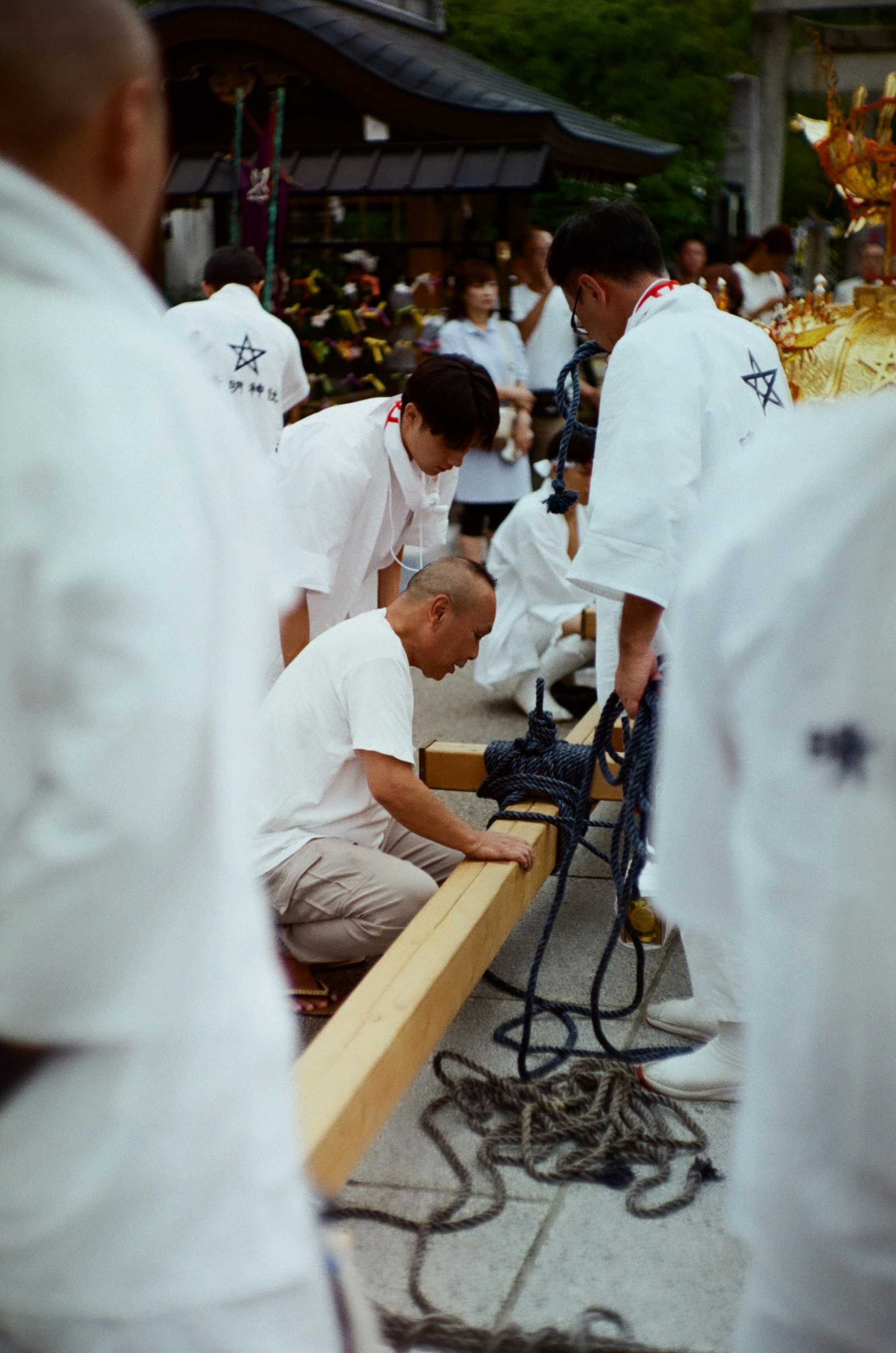 晴明祭の屋外で白装束の人々が楽器を準備する祭りの場