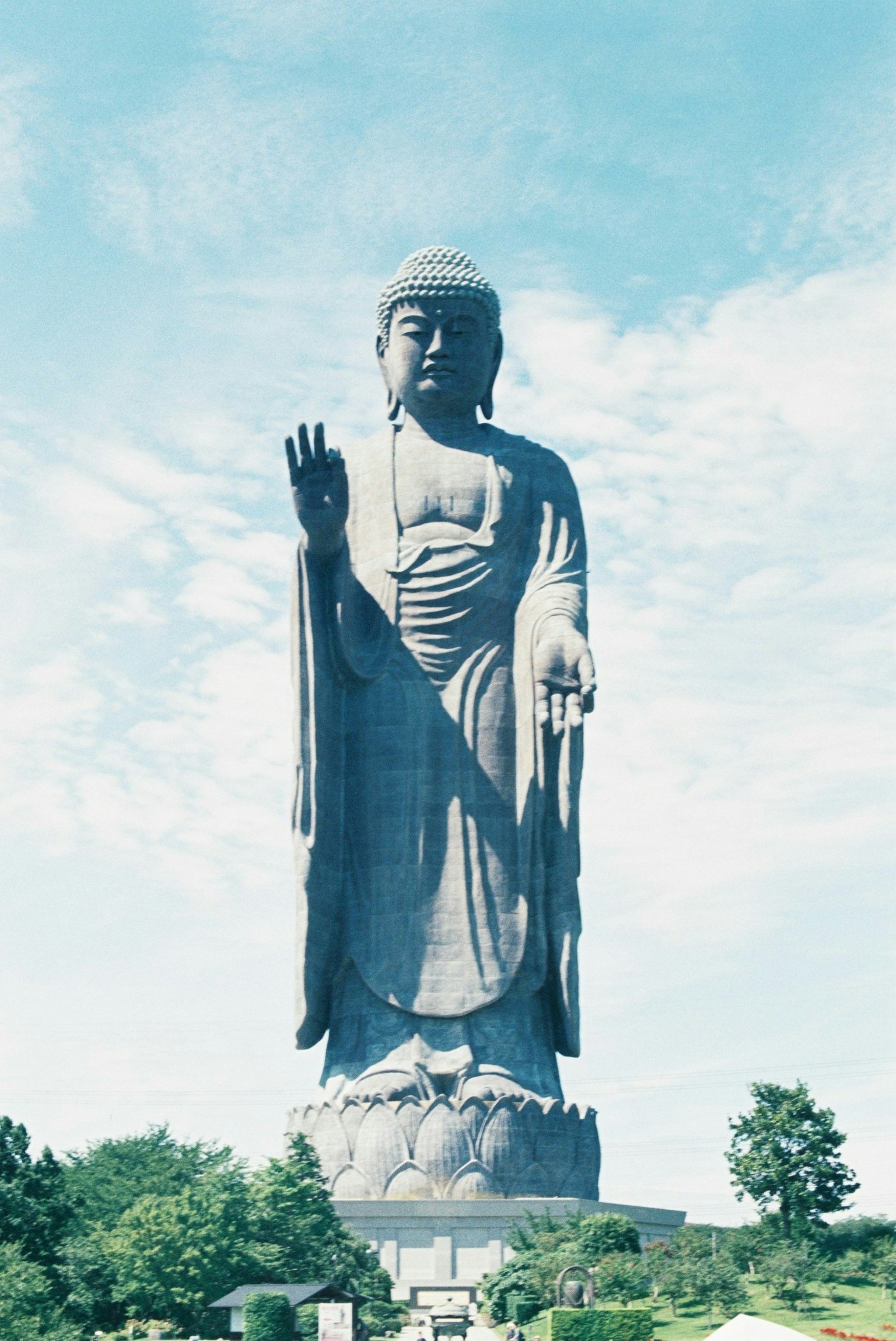 一座高耸的佛像在蓝天背景下