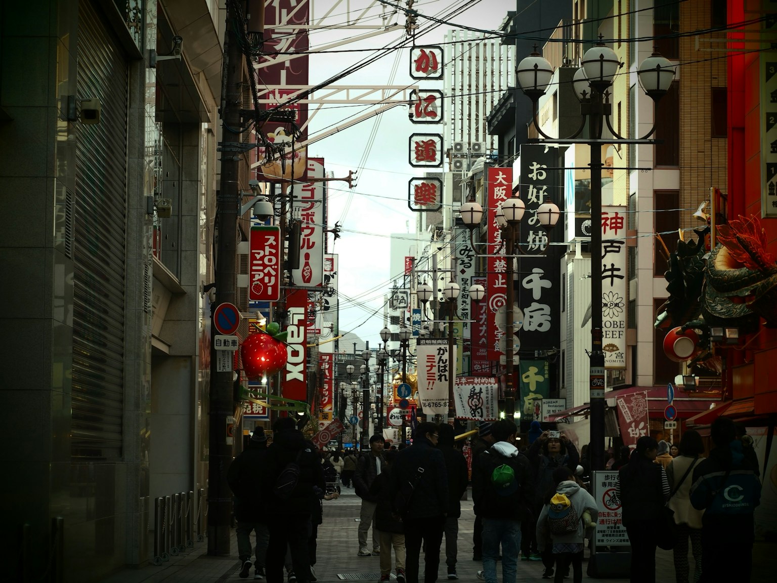 Scène de rue animée avec des gens marchant des enseignes colorées et des lanternes le long de la route
