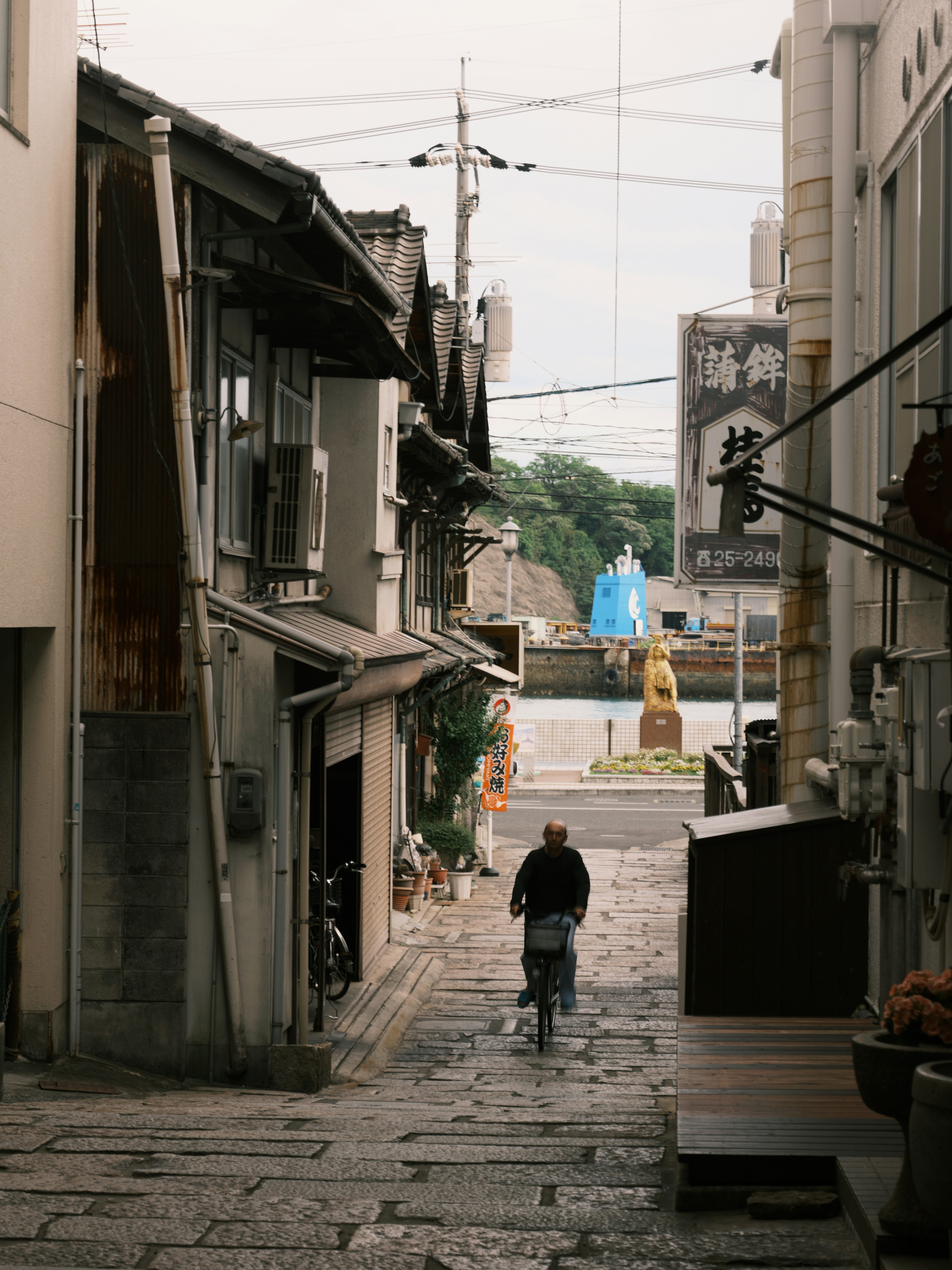 路地を歩く人と商店街の軒先