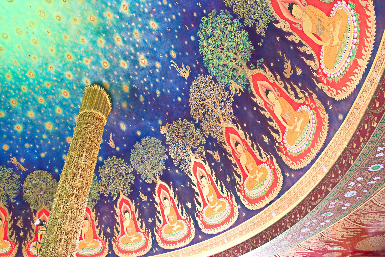 Decoración del techo con figuras de Buda coloridas sobre un fondo azul y verde