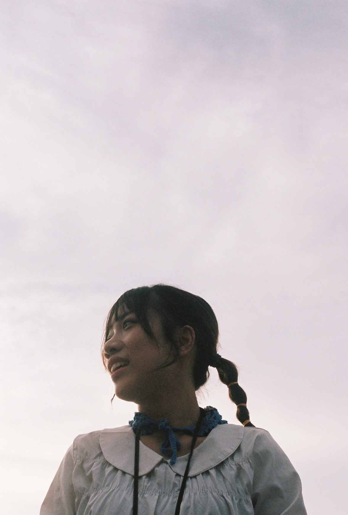 白い空を背景にした子どもの横顔