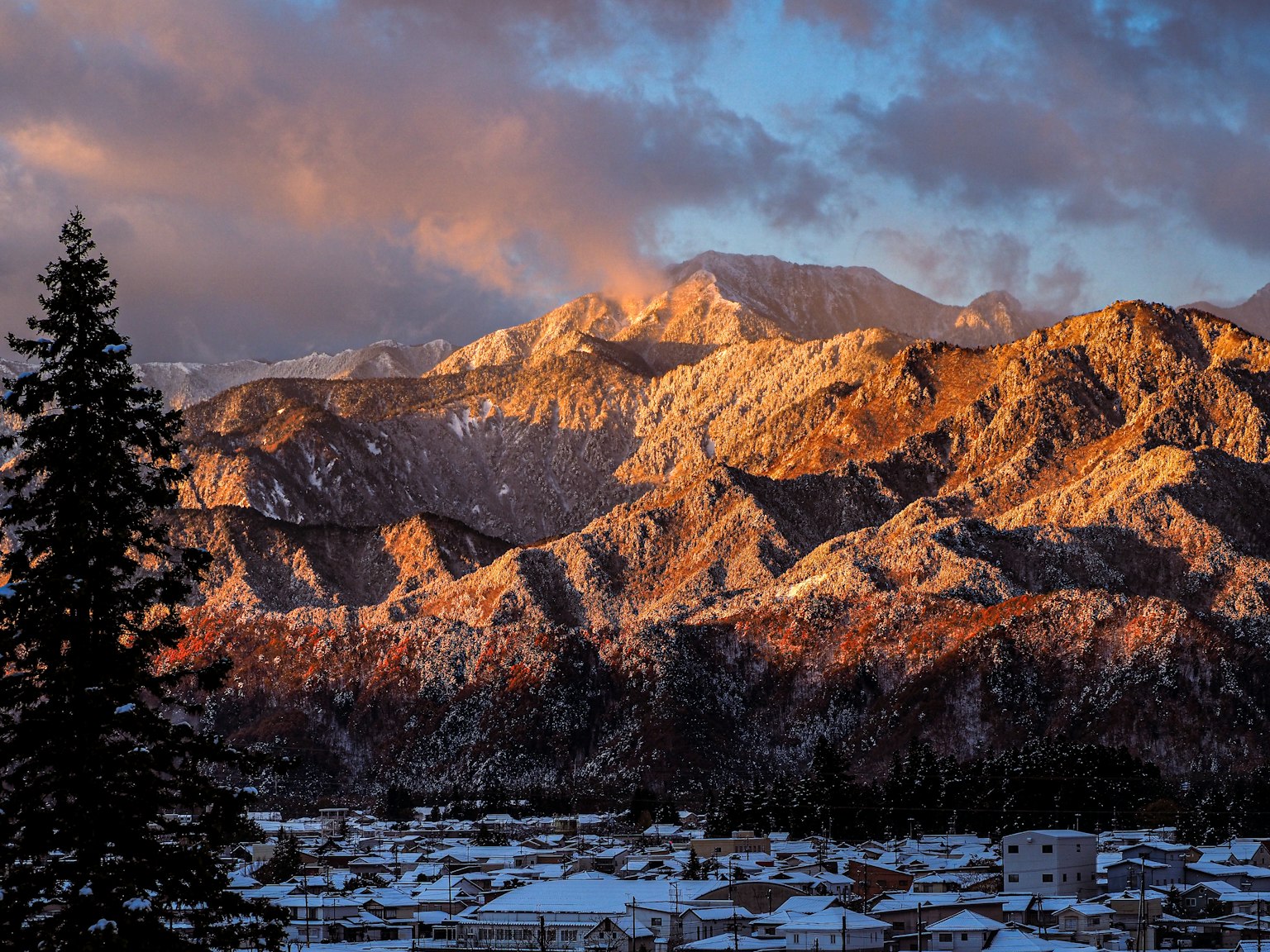 Snow-capped mountains with a sunset sky in the background