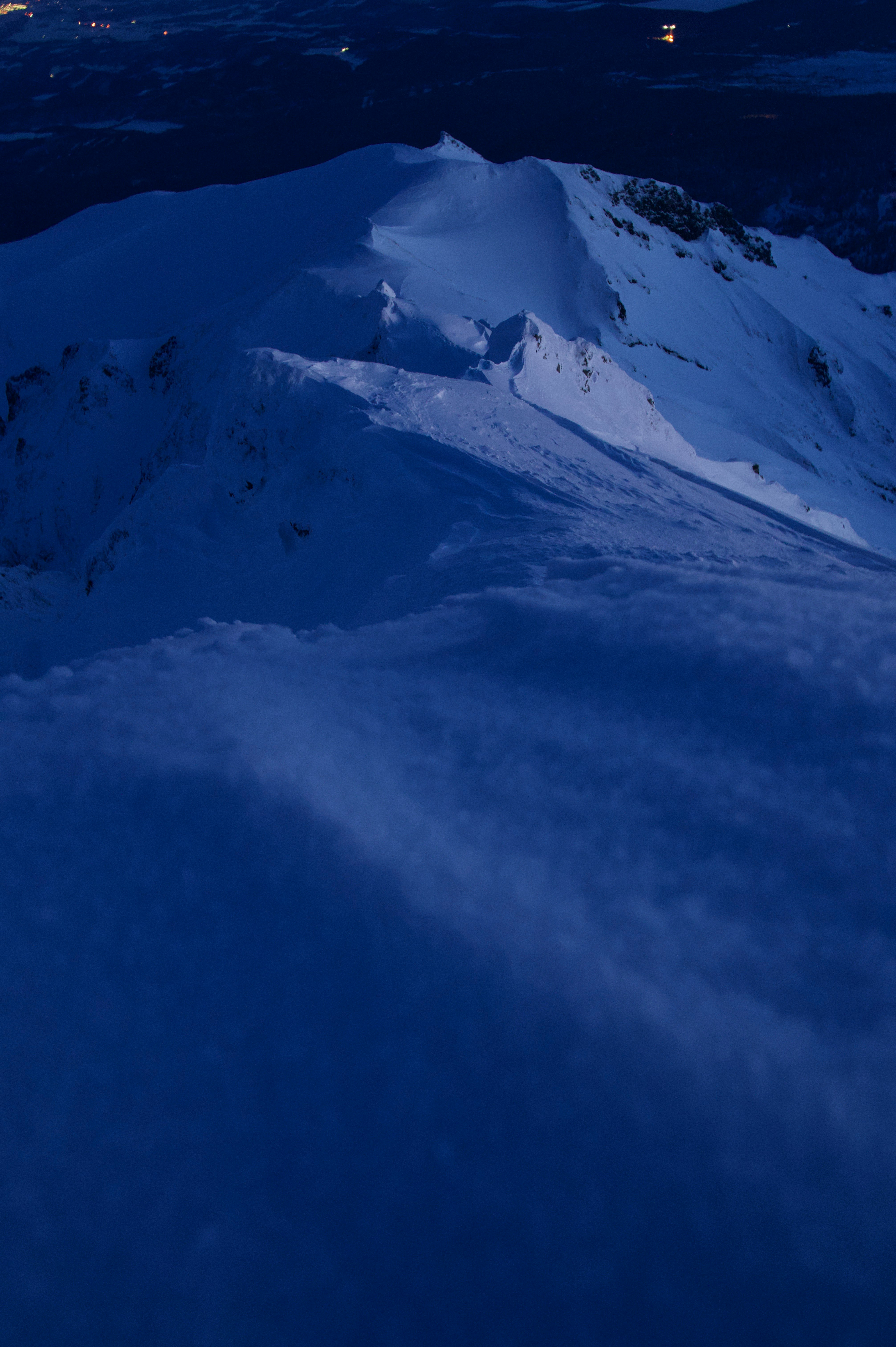 夜の雪山の稜線と谷の広がり