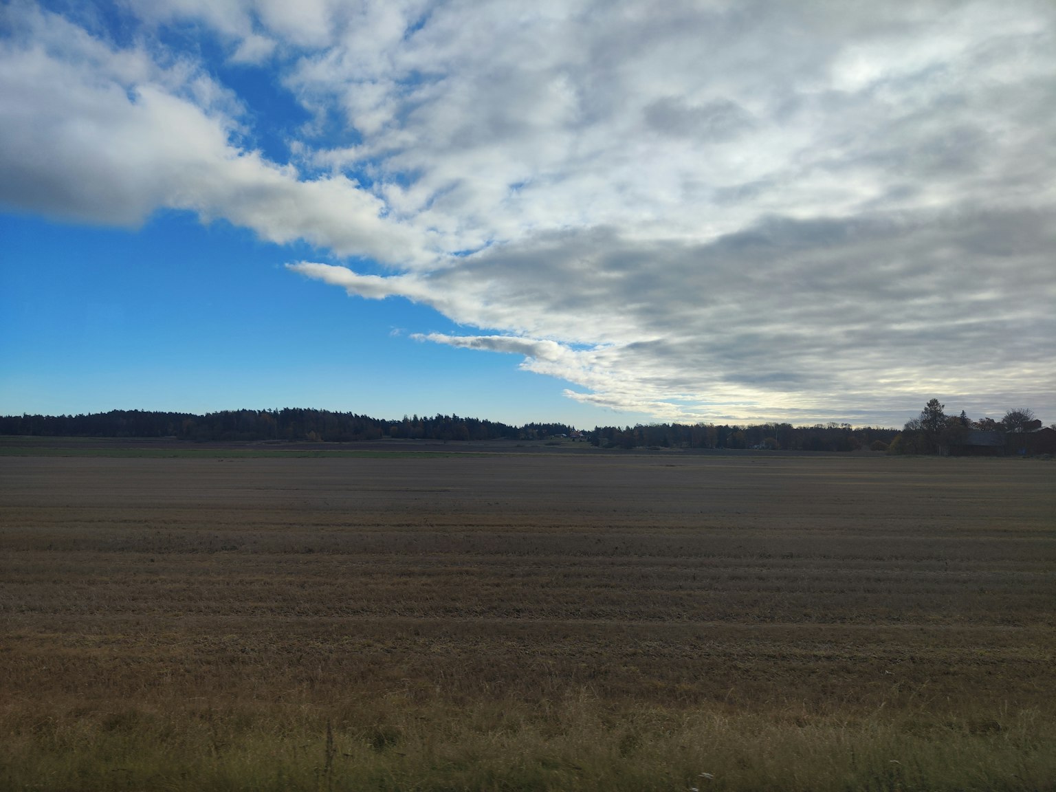 Paesaggio con cielo blu e nuvole su terreni agricoli estesi