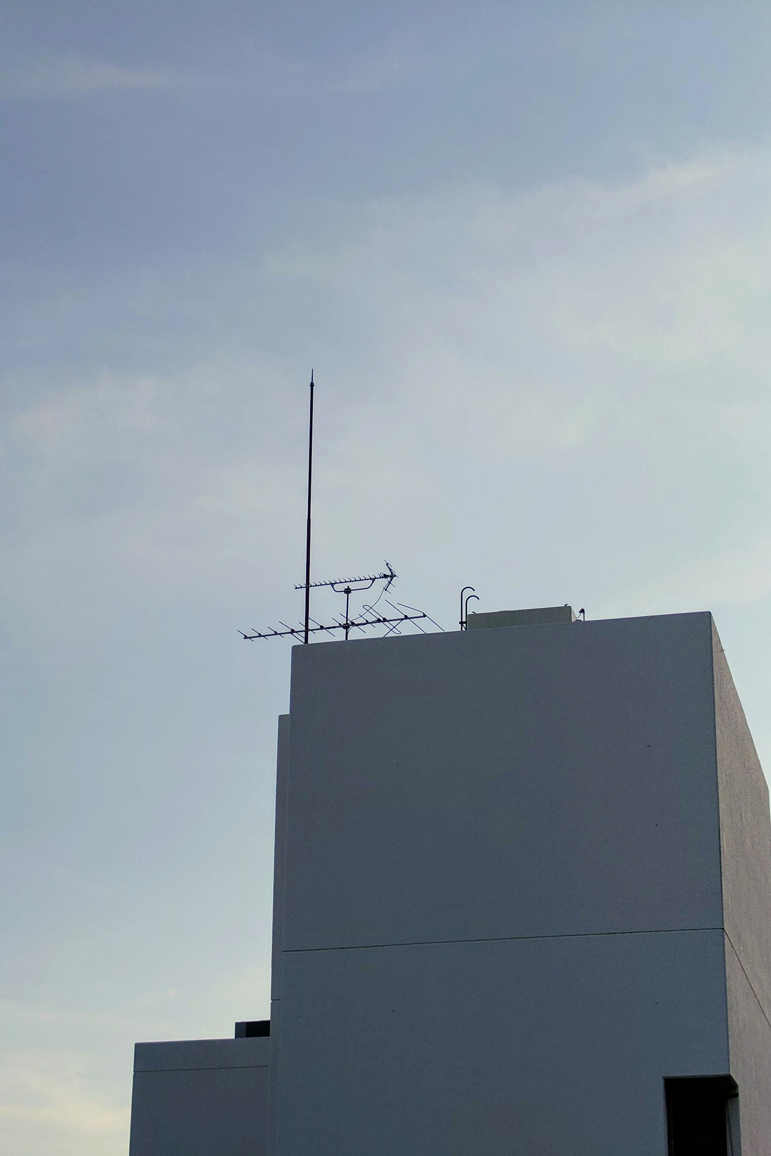 Un edificio bianco con antenne contro un cielo blu