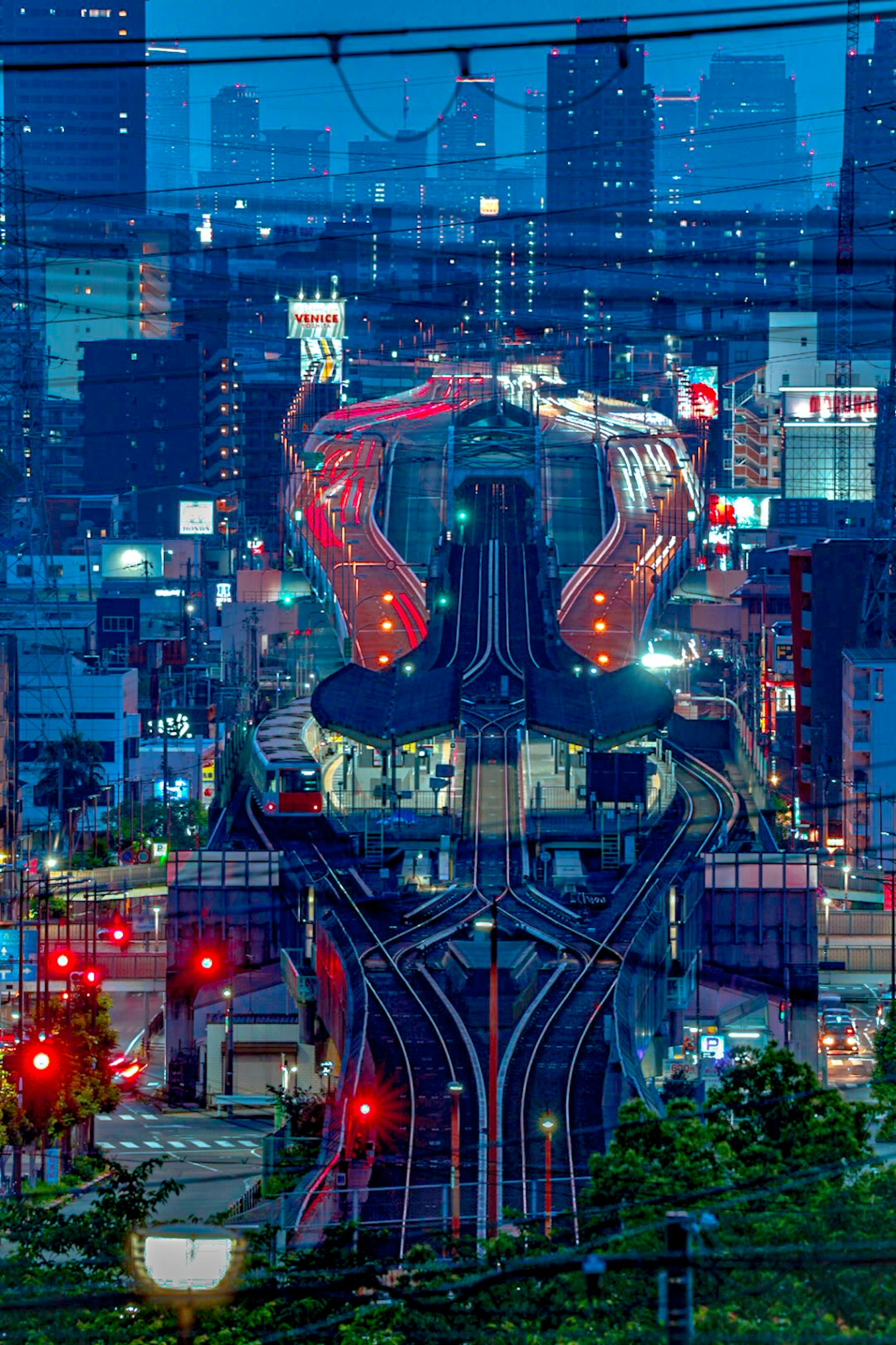 Paesaggio urbano notturno con incrocio ferroviario e edifici illuminati