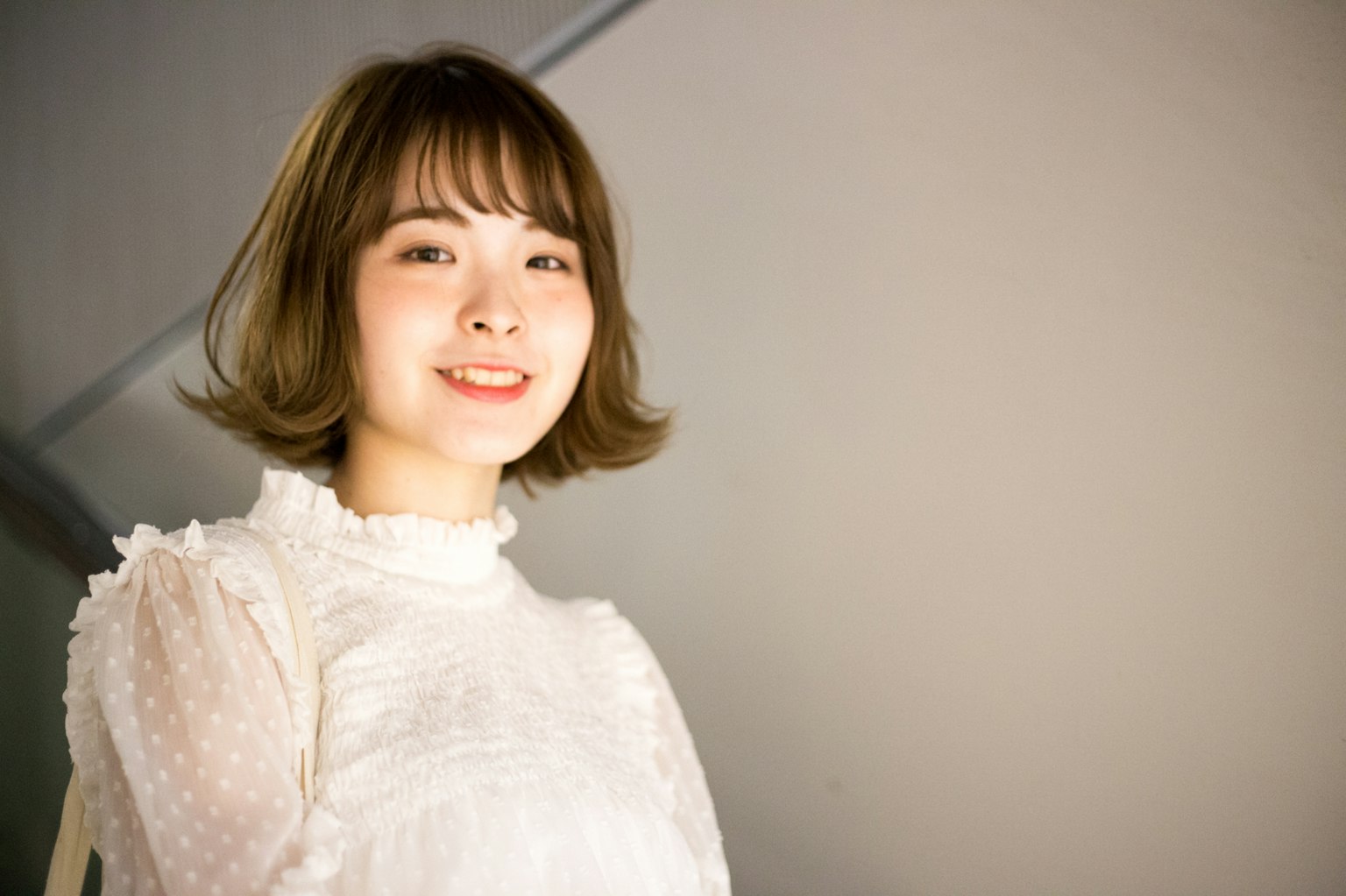 Una mujer sonriendo con blusa blanca