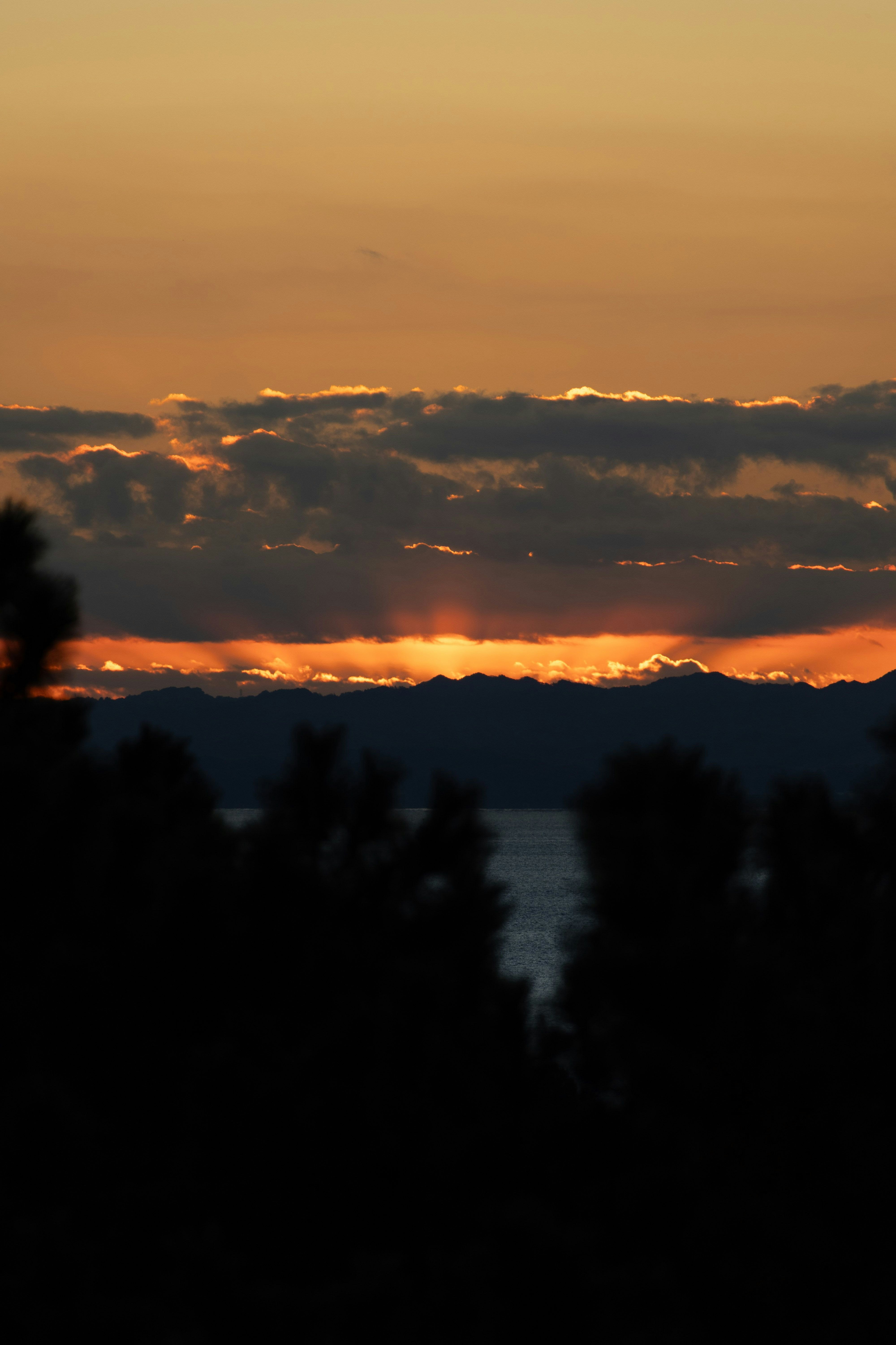 夕焼けの雲と山並みを見下ろす夜明け前の景色