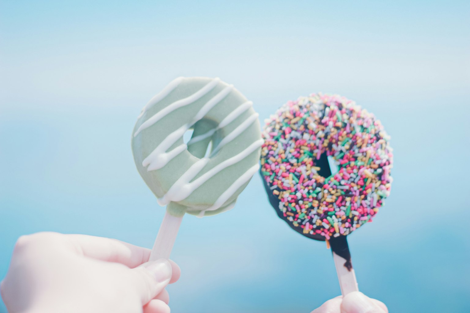 Deux donuts glacés devant un fond bleu