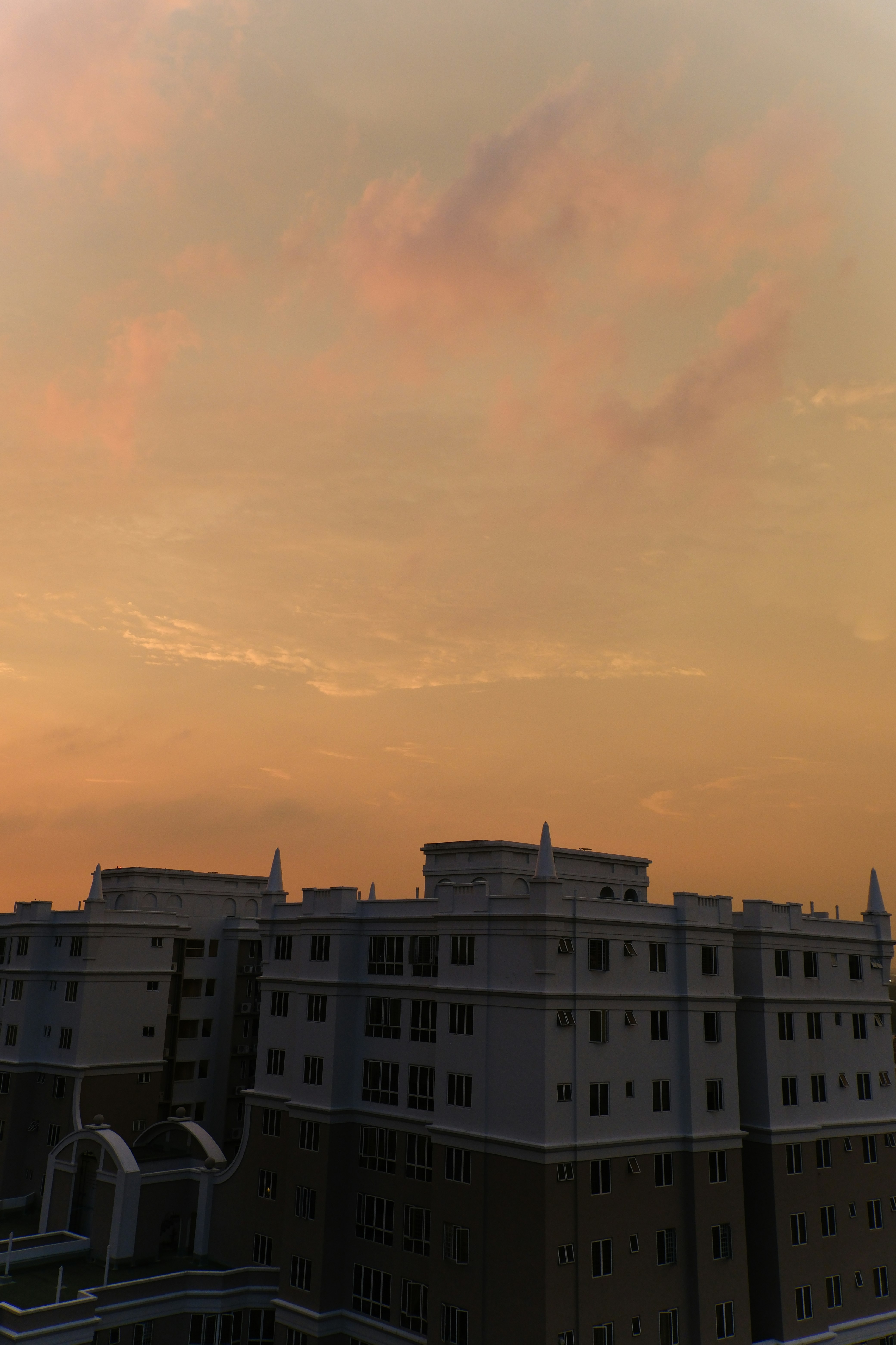 夕阳天空下的住宅楼屋顶与塔楼