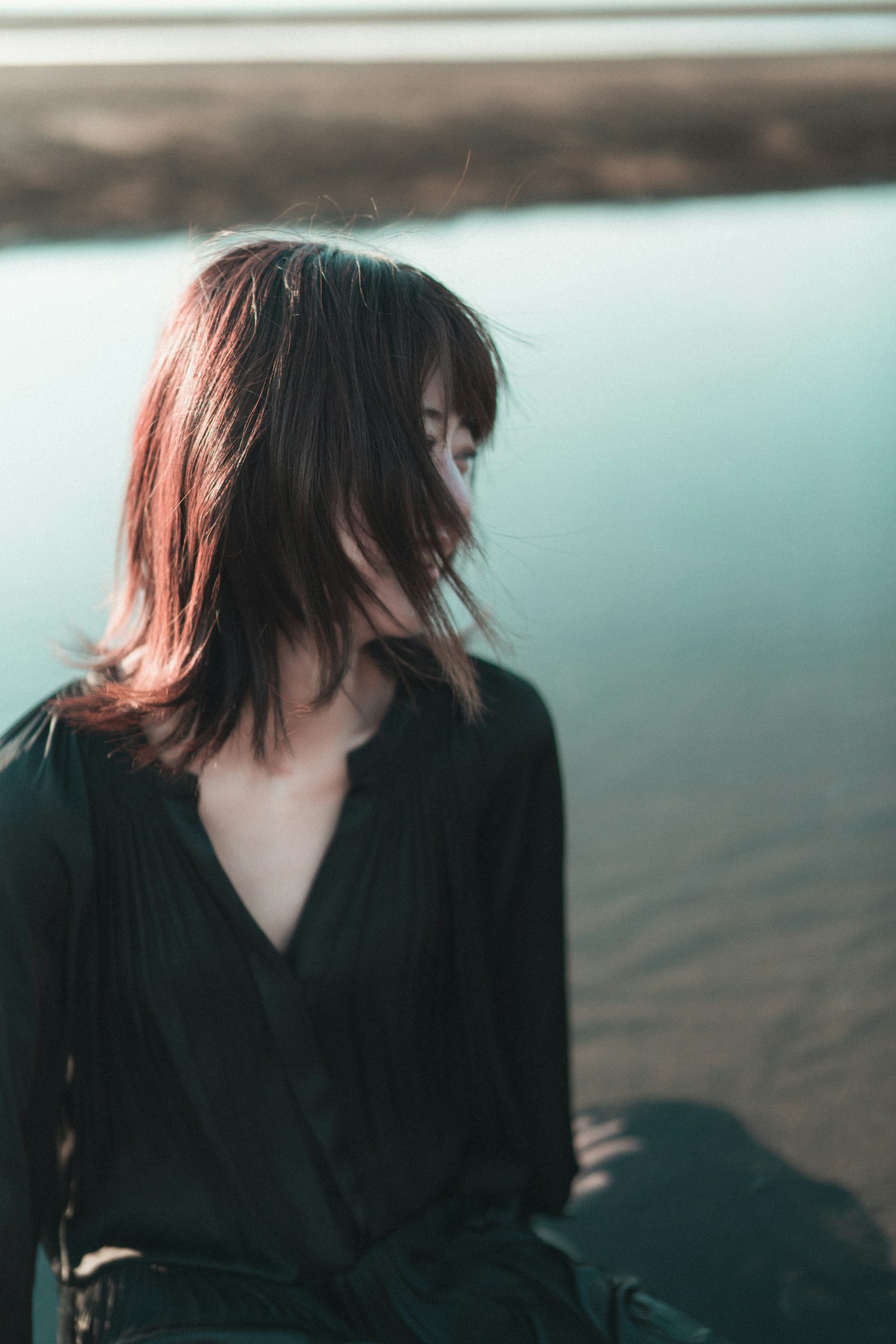 水边一位头发飘动的女性侧面