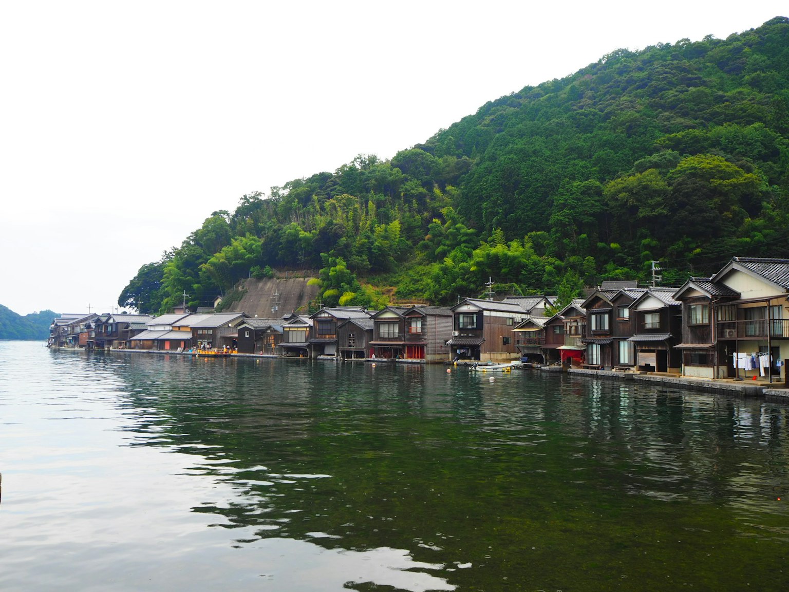 Cảnh đẹp của một làng chài truyền thống phản chiếu trên mặt nước tĩnh lặng với những ngọn đồi xanh