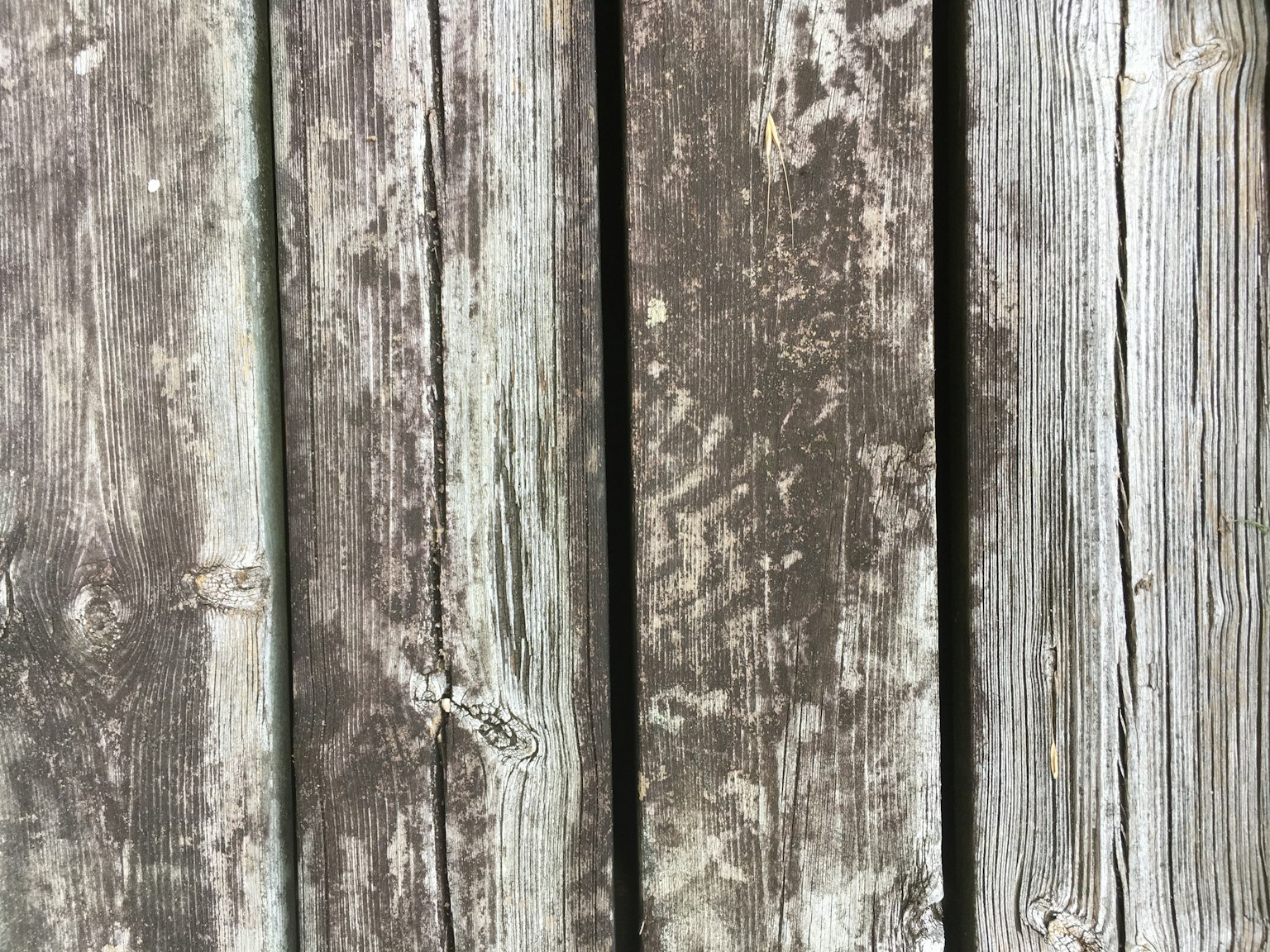 Nahaufnahme von verwitterten Holzplanken mit einzigartigen Texturen und Farben