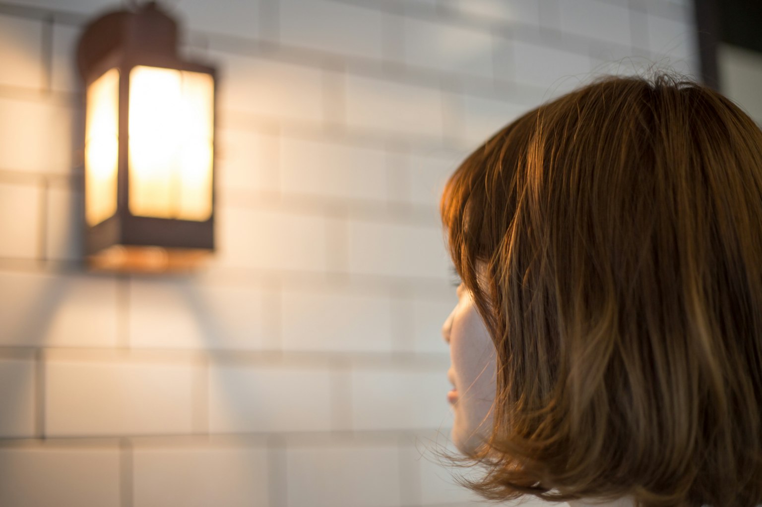 Una mujer mirando una linterna de pared