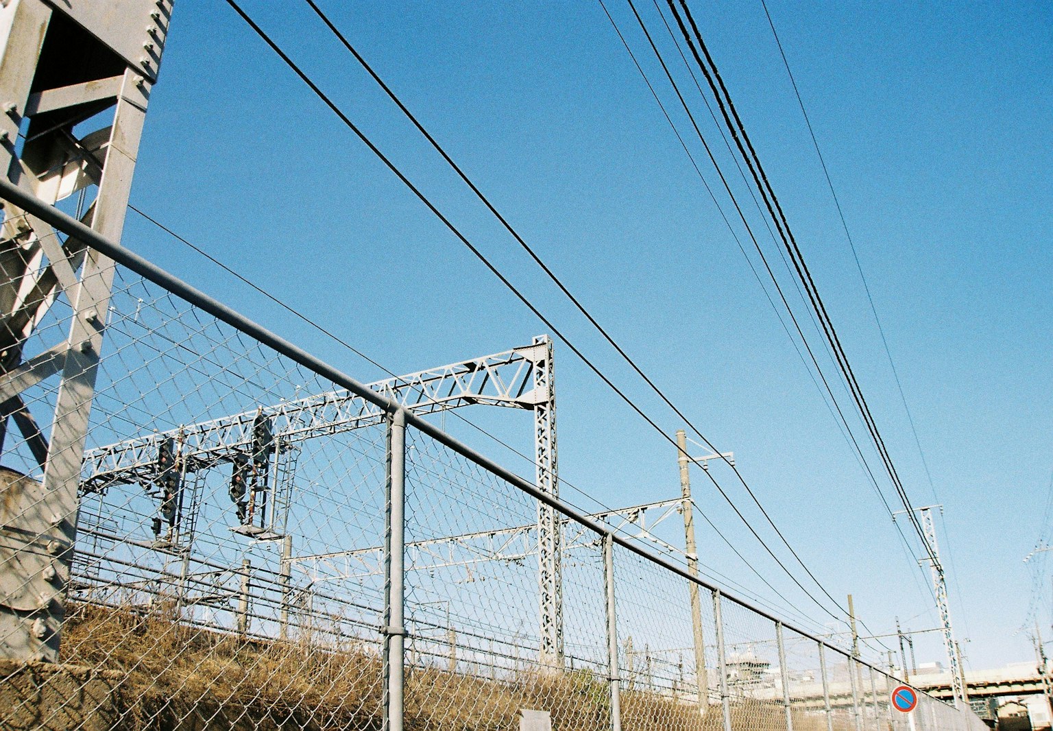 Vista delle linee elettriche ferroviarie e del cancello sotto un cielo blu
