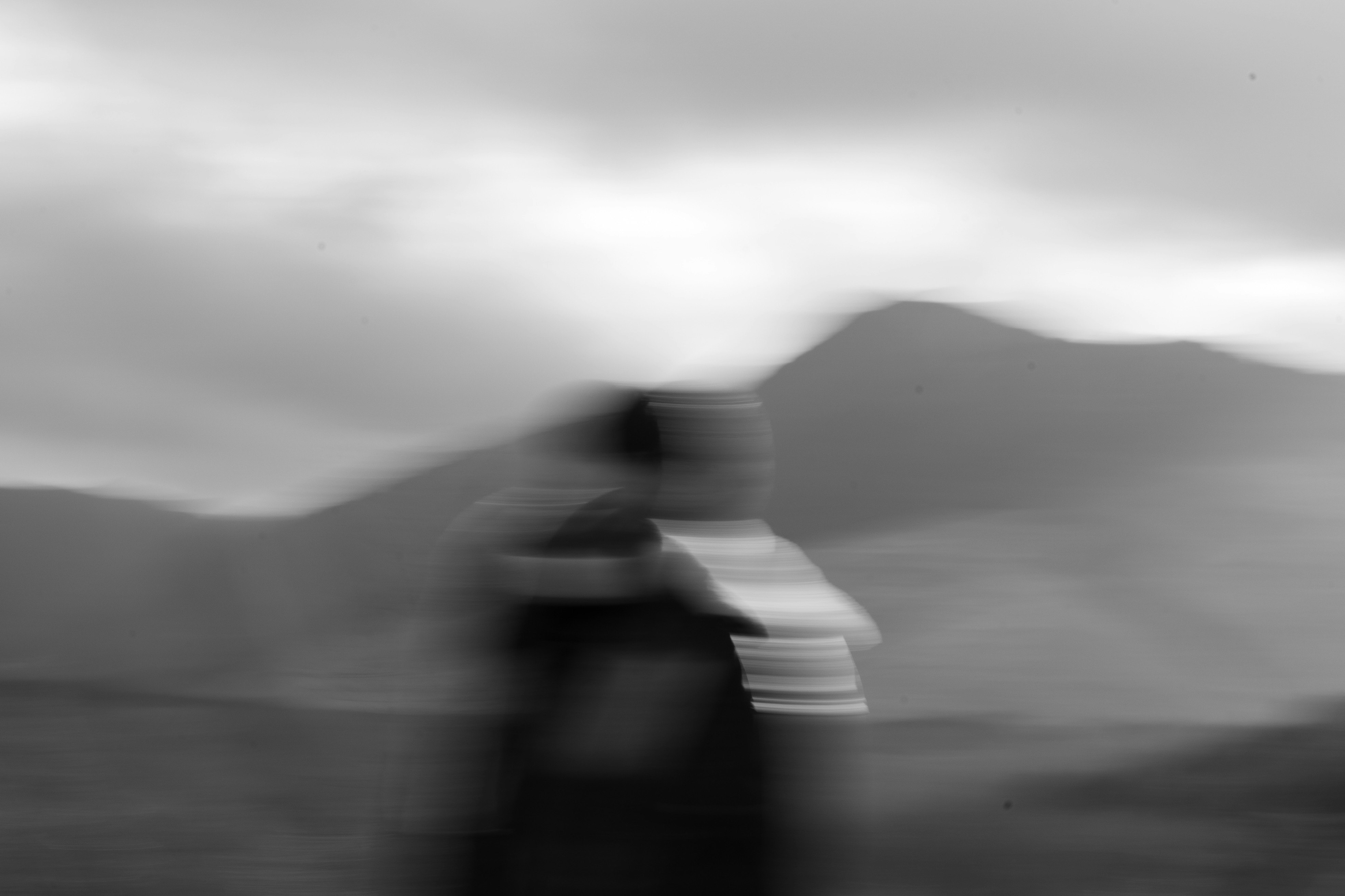 霧の中を走る人影のブレたストリートシーン