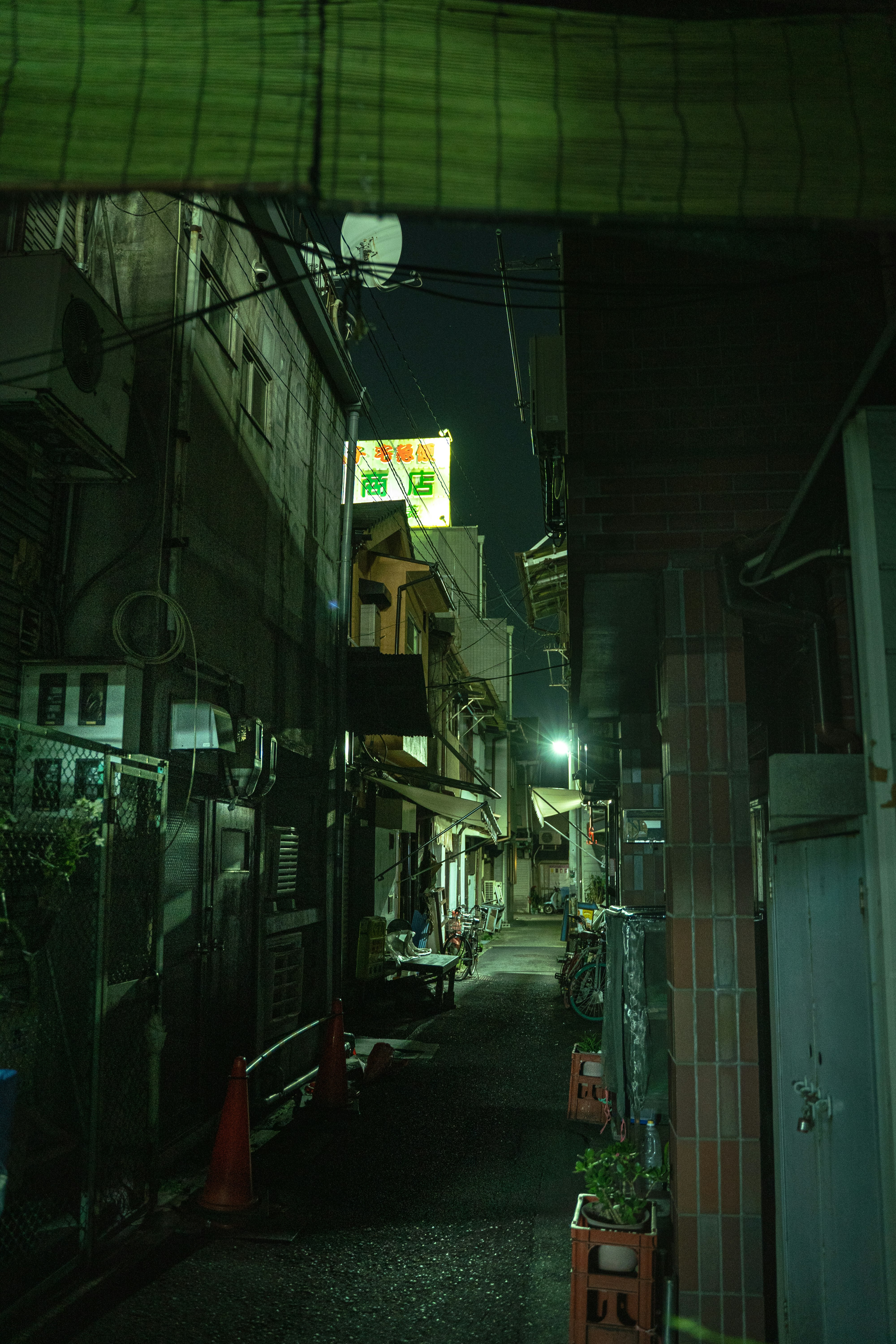 夜の路地に並ぶ看板と街灯のある商店街の軒先
