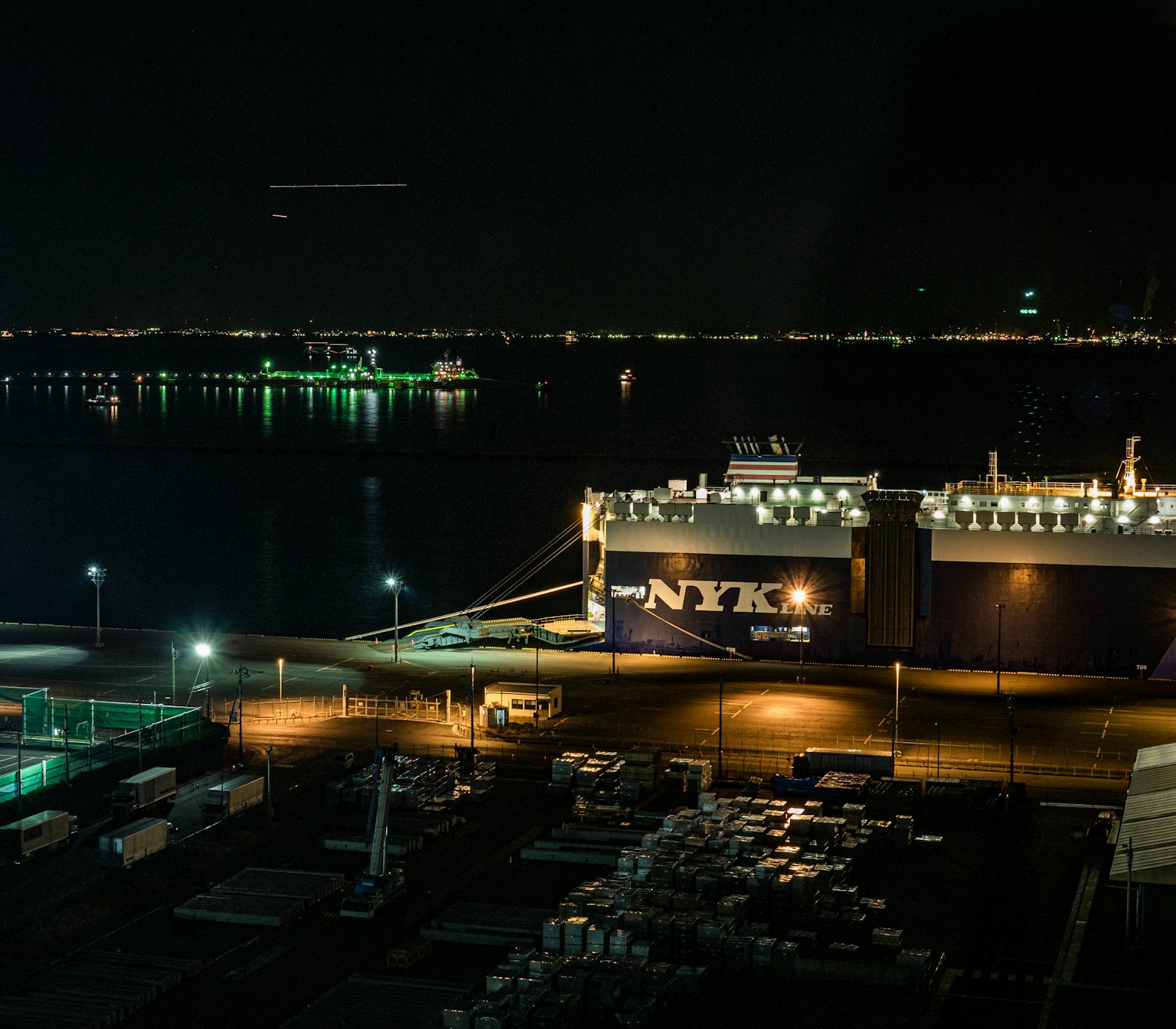 Night view of a port with illuminated ships and water surface