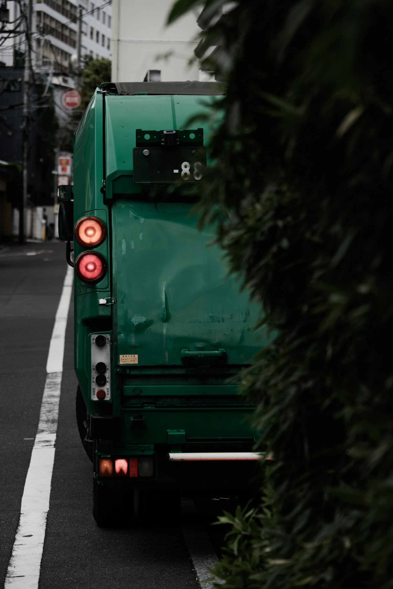 Camion poubelle vert garé à côté de la rue