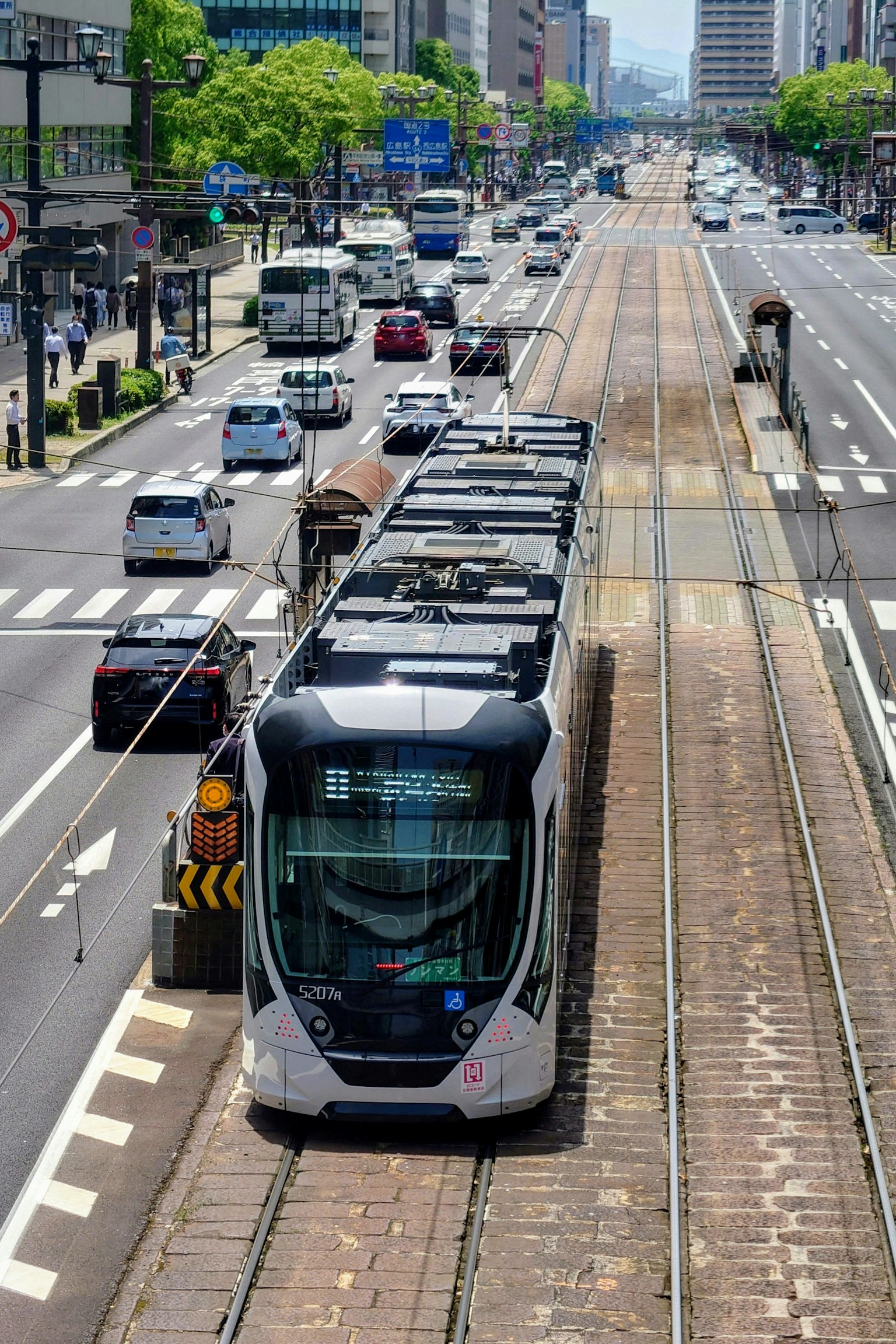 Tram urbano en movimiento con tráfico mixto y paisaje urbano