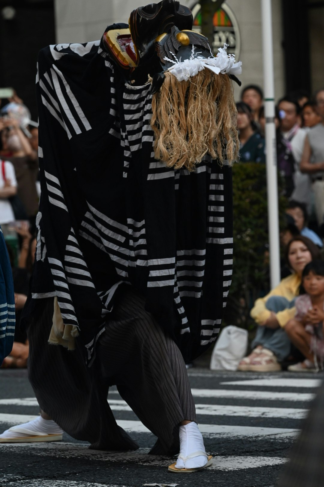 costumed person posing on a crosswalk in the street