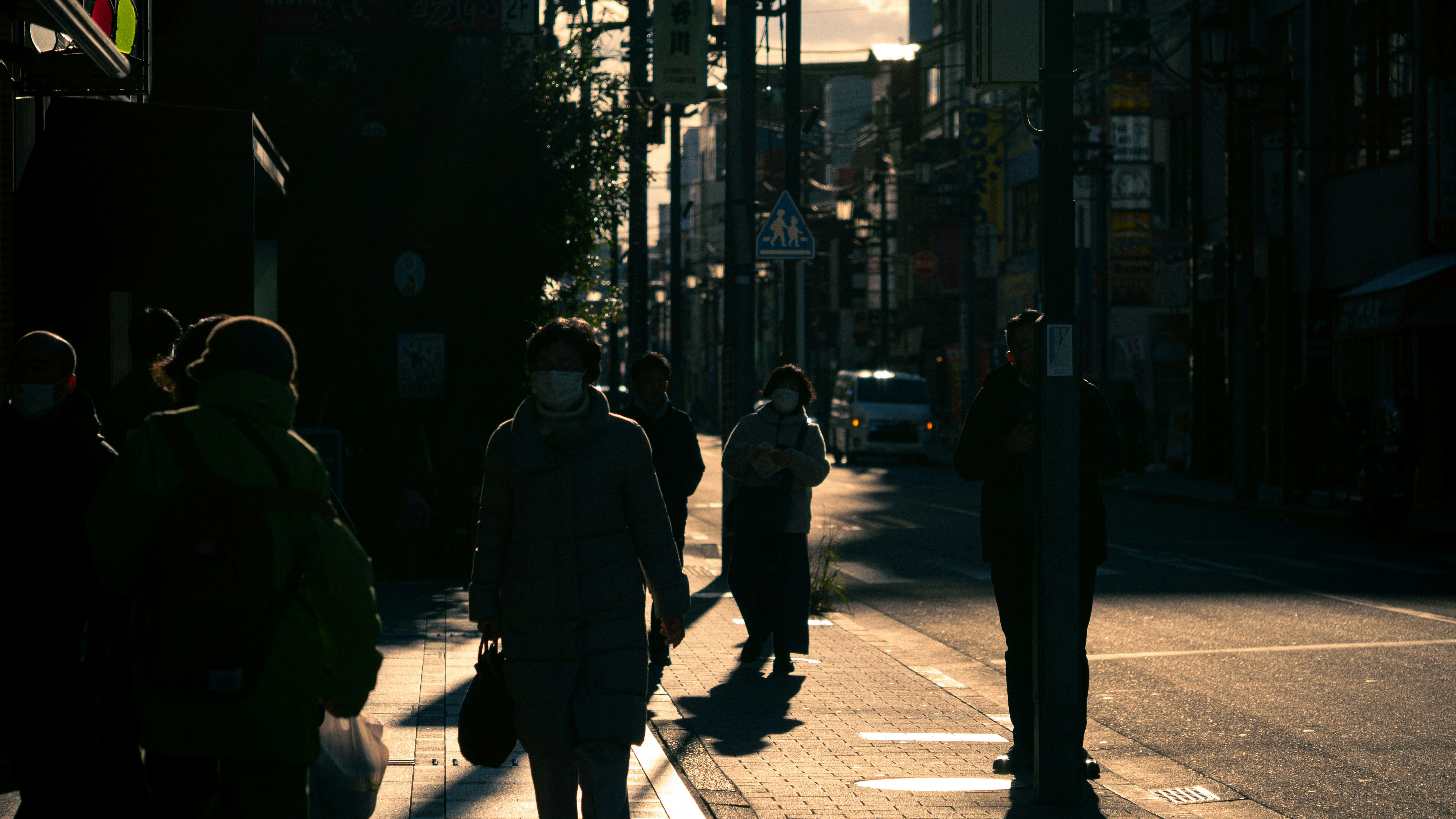 personas caminando por una calle urbana al atardecer